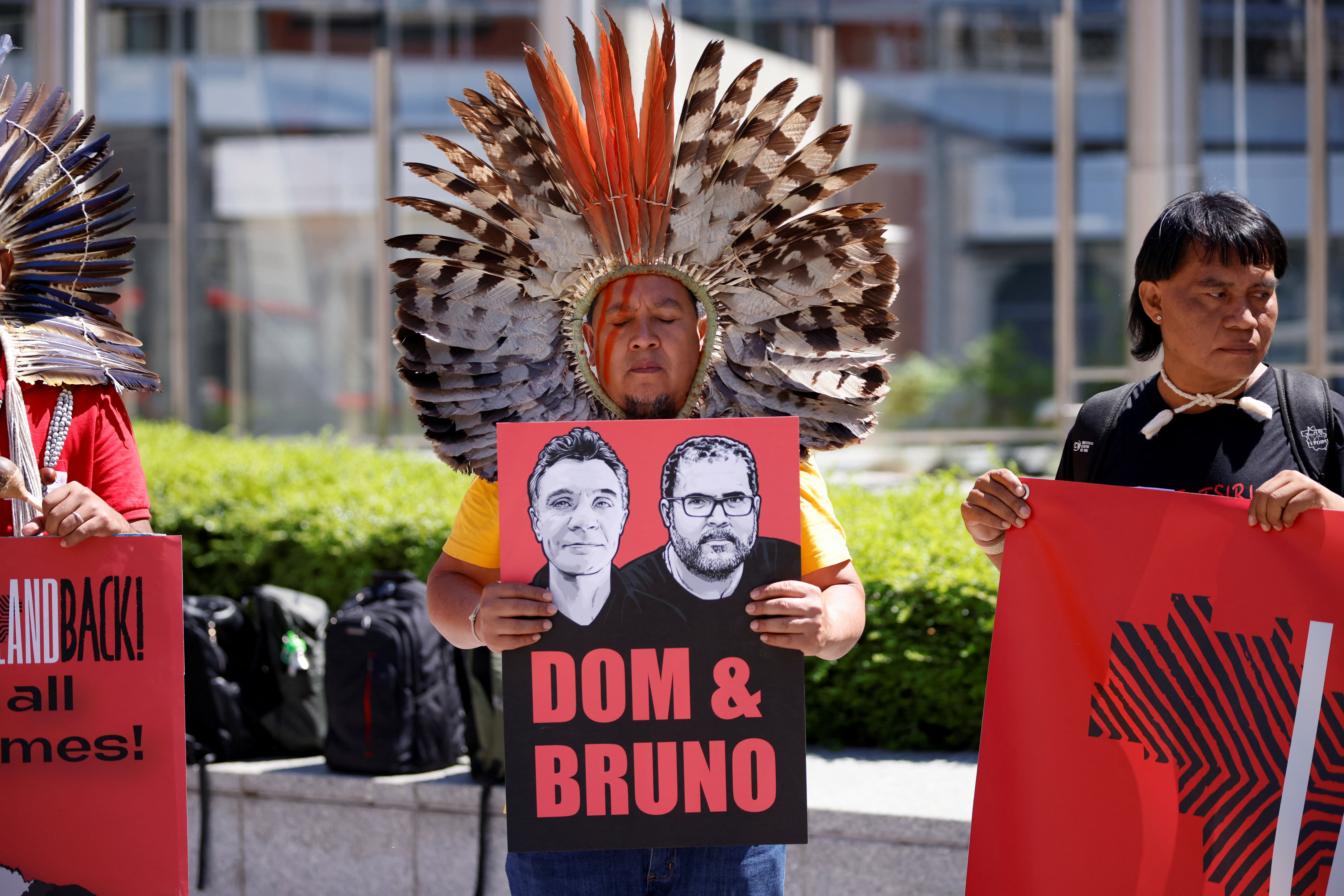 Un miembro de la Articulación de Pueblos Indígenas de Brasil (APIB) sostiene una pancarta con retratos del periodista británico Dom Phillips y el experto indígena brasileño Bruno Pereira