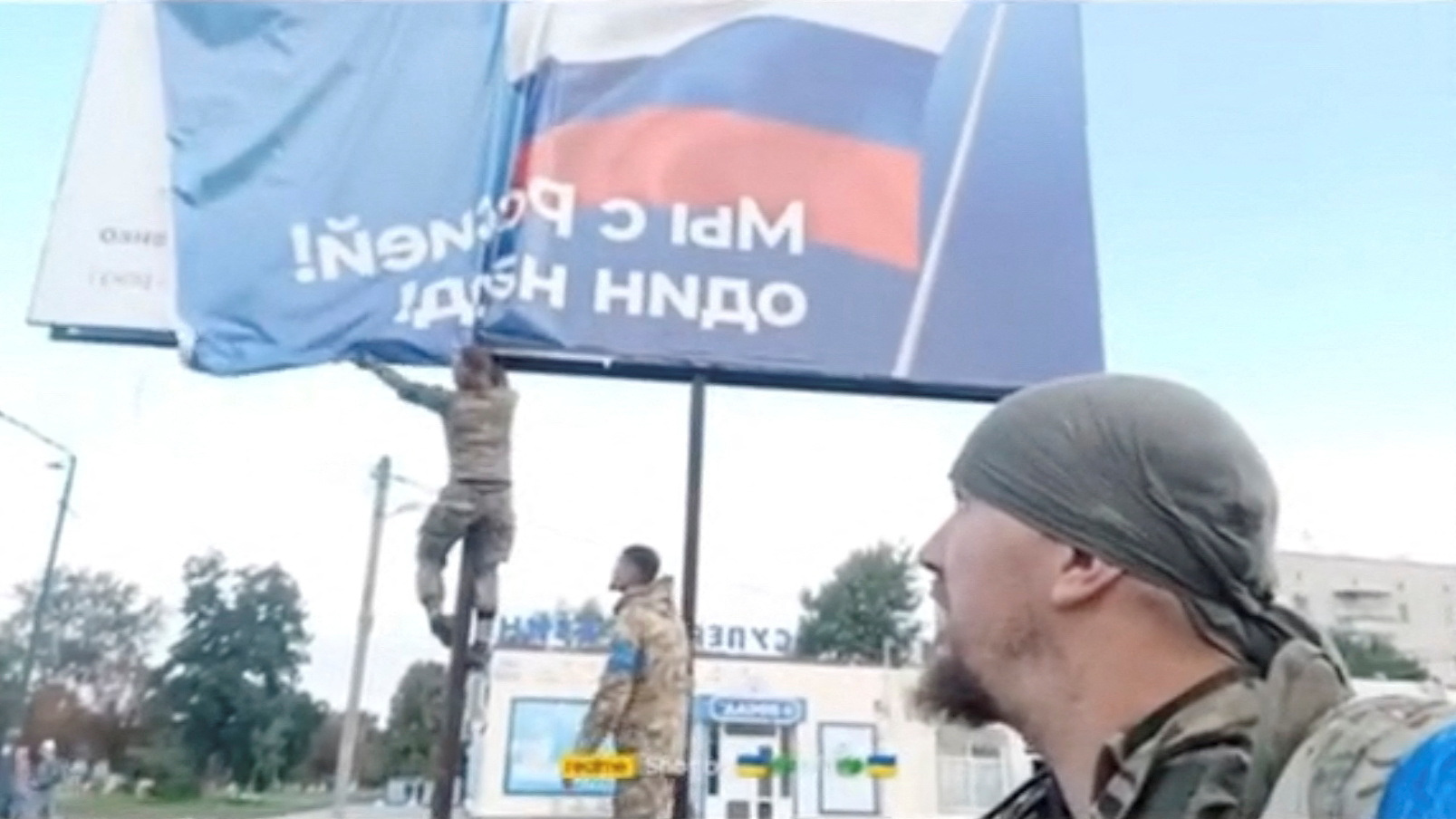 Los militares ucranianos sacan un cartel ruso de una valla publicitaria, revelando un poema del poeta nacional ucraniano Taras Shevchenko en Balakliia (Reuters)