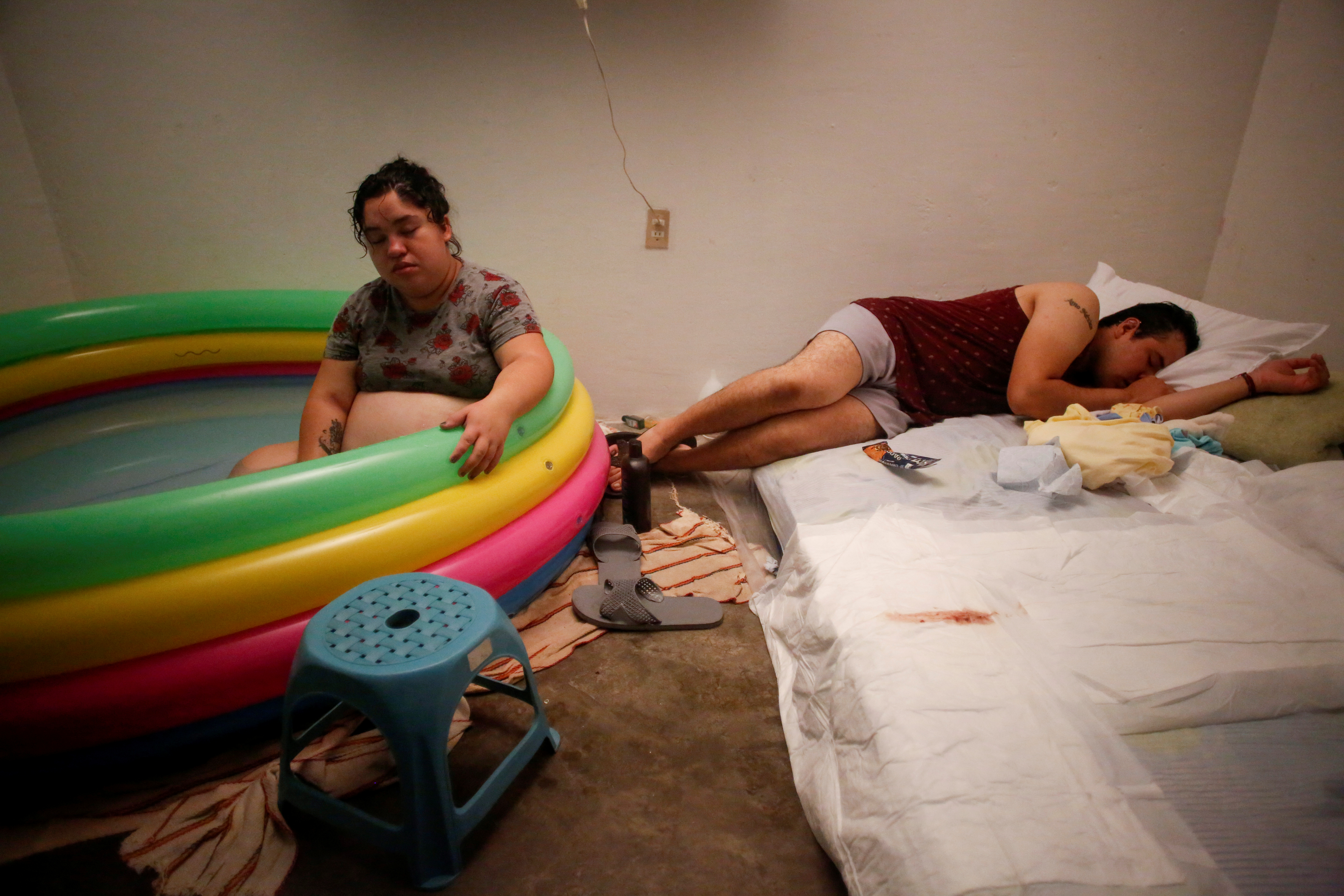 Miguel Flores Torres descansa en una cama junto a su esposa Karla López Rangel, que está embarazada, se sienta en una piscina de parto inflable en Xochimilco, Ciudad de México, México, 25 de mayo de 2020. Foto: REUTERS / Gustavo Graf