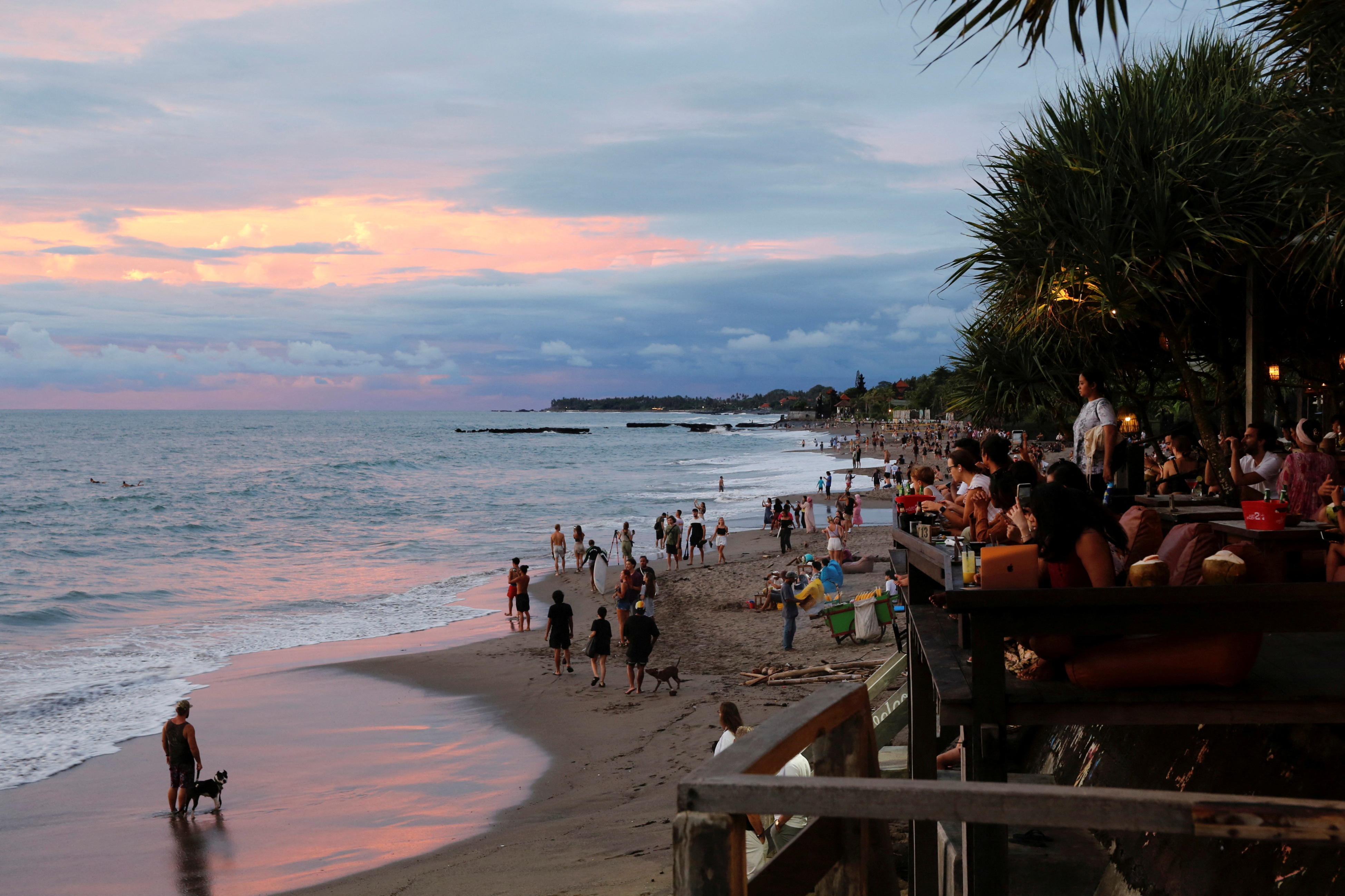 FILE PHOTO: Tourists enjoy the sunset at Canggu beach amidst the coronavirus disease (COVID-19) pandemic in Bali, Indonesia, December 2, 2021. REUTERS/Johannes P. Christo/File Photo