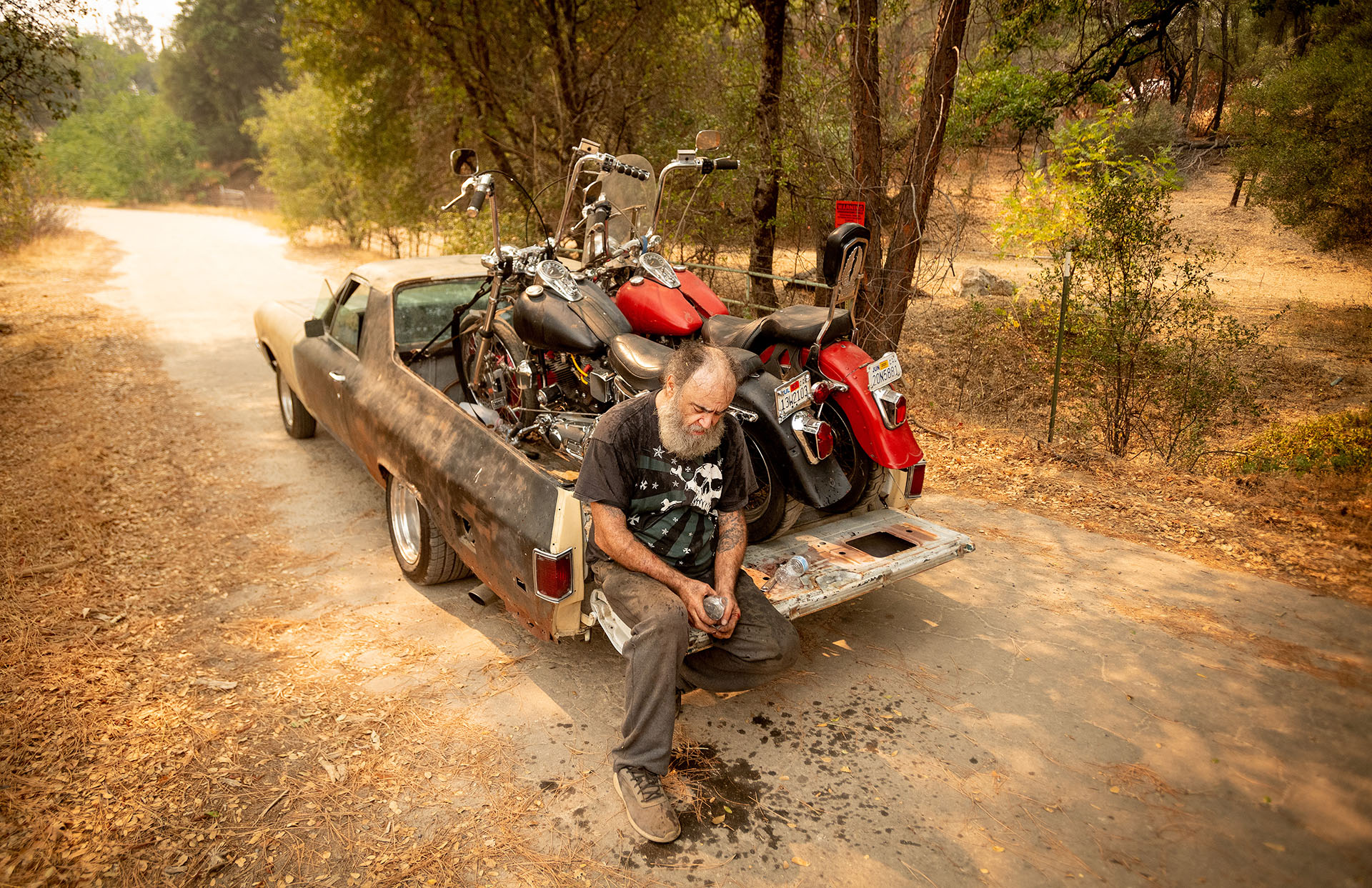 Jim Smart descansa en la parte trasera de su vehículo después de evacuar con dos de sus preciadas motocicletas durante el incendio de Creek (Foto de JOSH EDELSON / AFP)