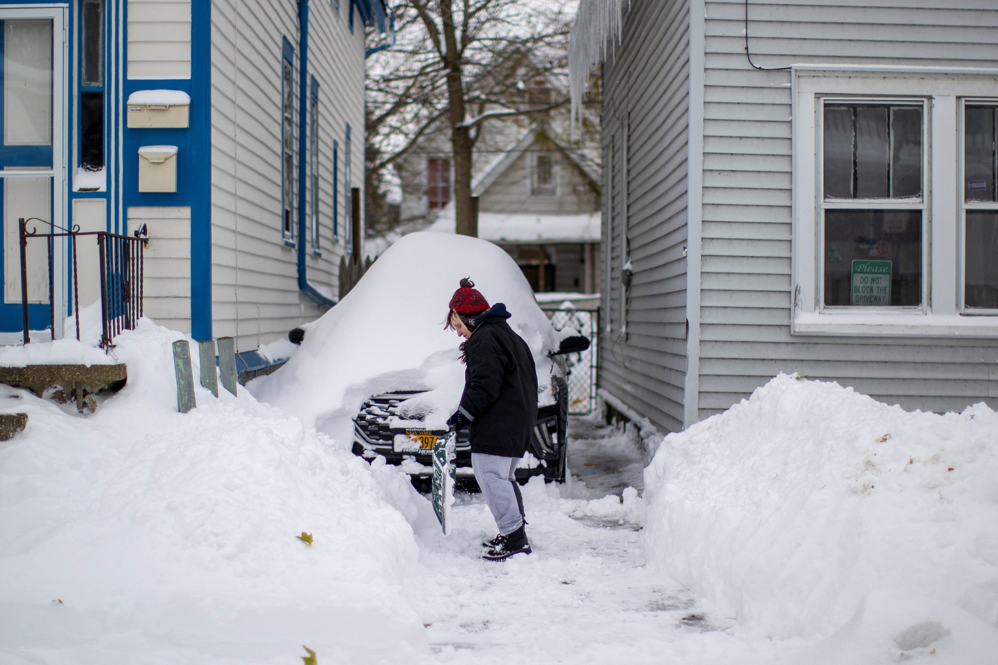 Una mujer quita la nieve sobre el auto de su hija en Buffalo
