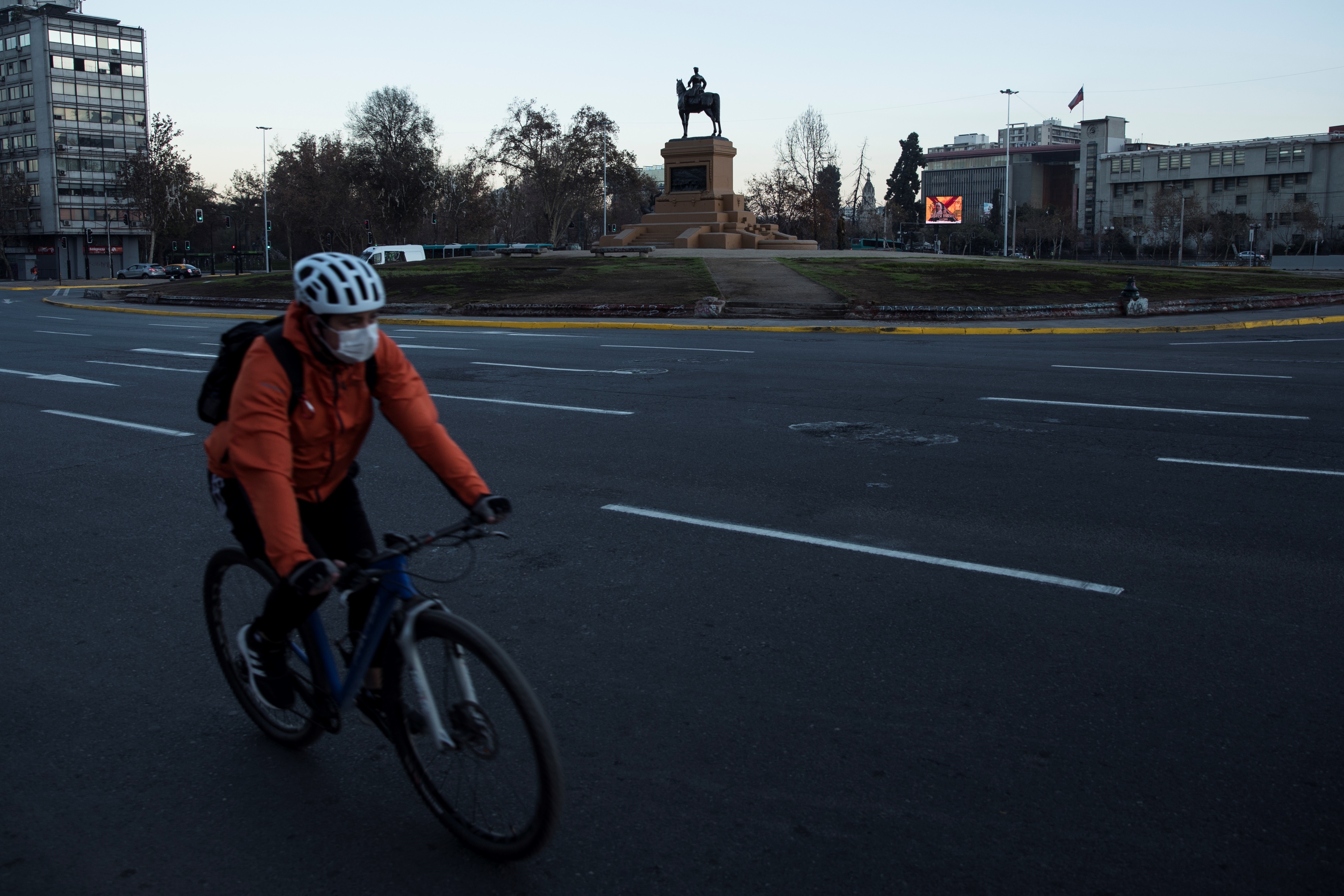 Un ciclista con mascarilla como medida para evitar el contagio con coronavirus para frente a la Plaza Italia el 16 de mayo de 2020 en Santiago (Chile). EFE/Alberto Valdés.