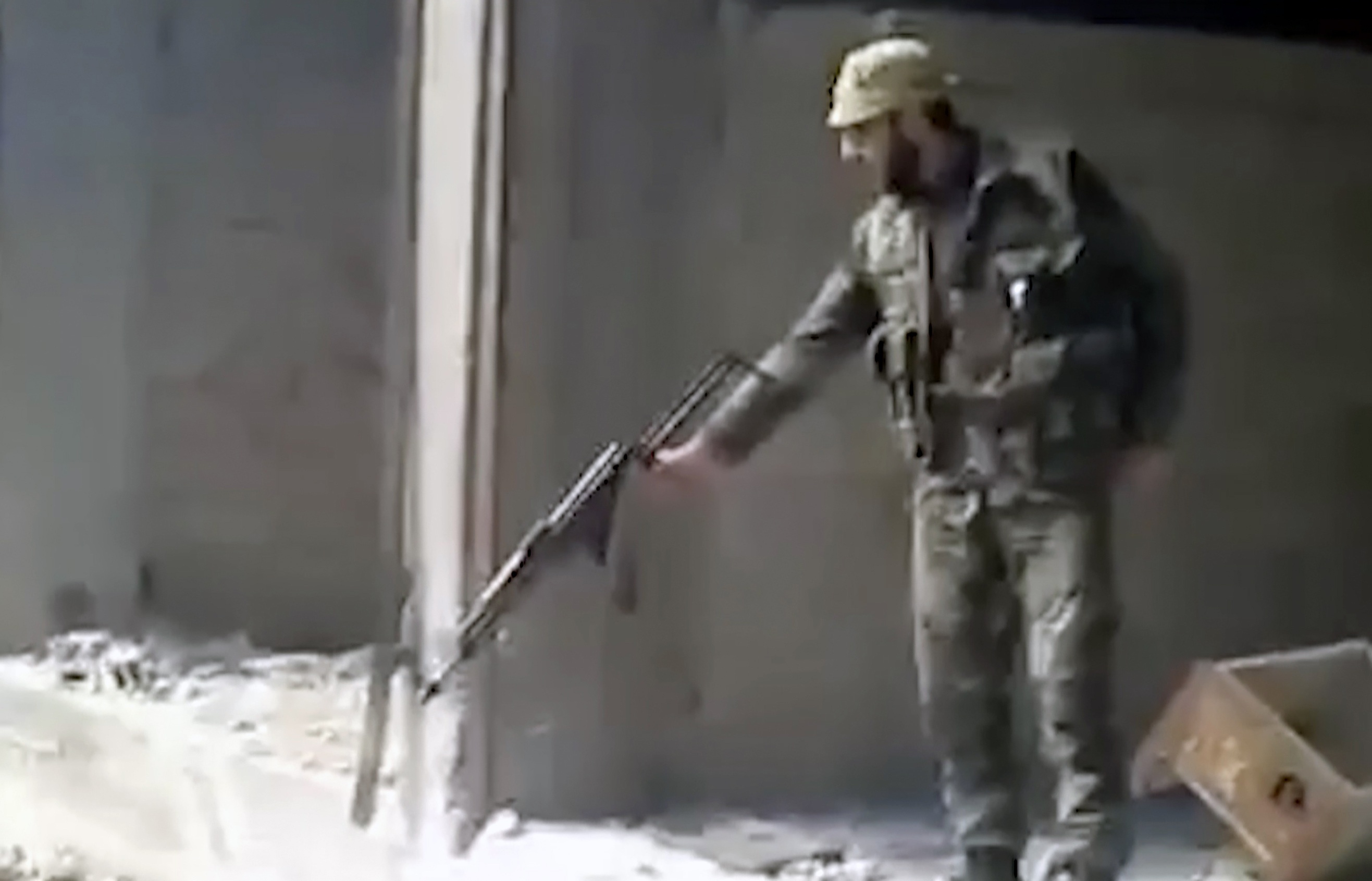 Esta captura de fotograma de un video de 2013 muestra a un soldado sirio disparando a un gran pozo lleno de cuerpos, en el barrio Tadamon de Damasco, Siria. (AP Photo, archivo)