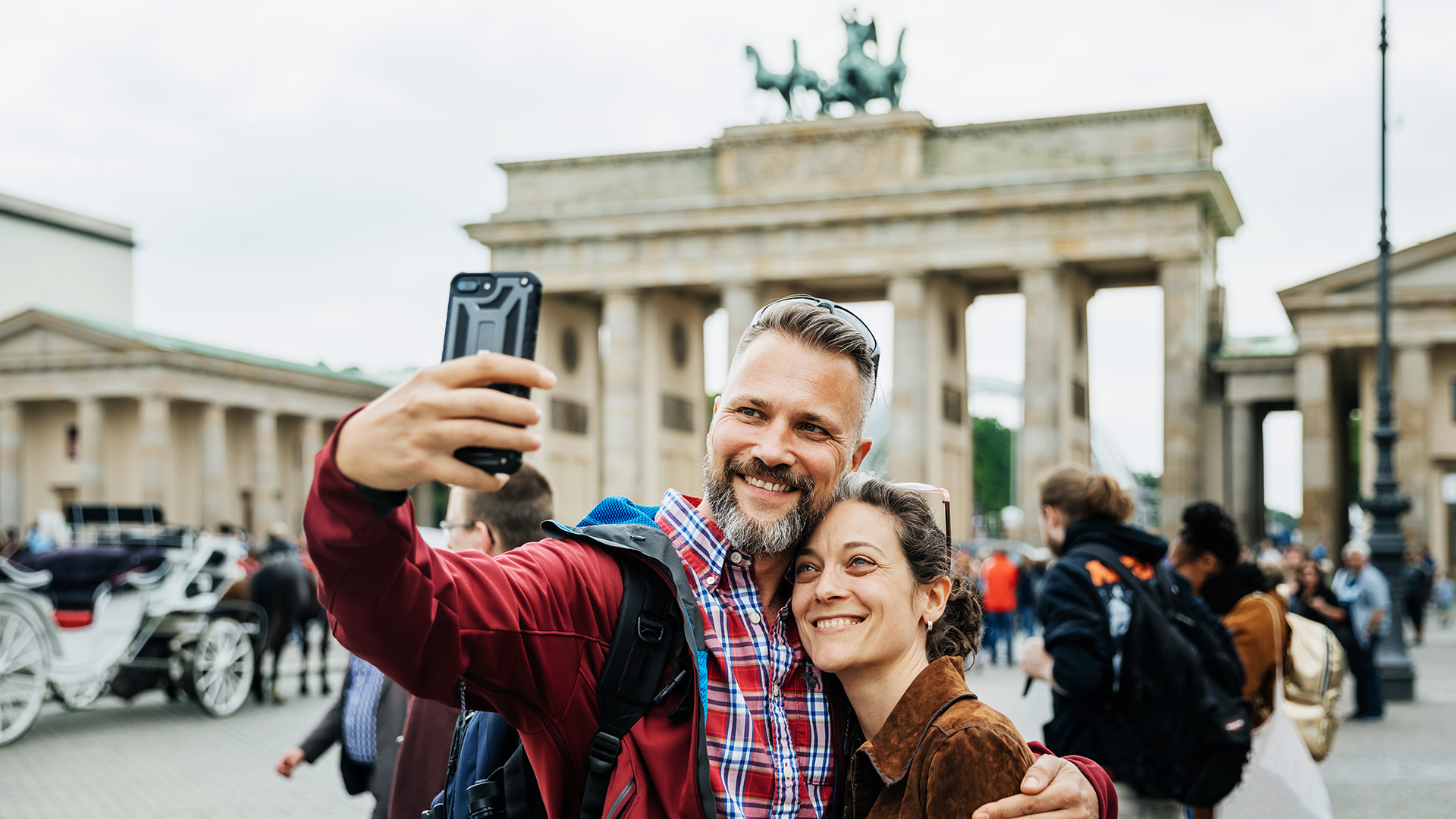Una pareja se toma una selfie con la Puerta de Brandeburgo de espaldas, en Berlín

