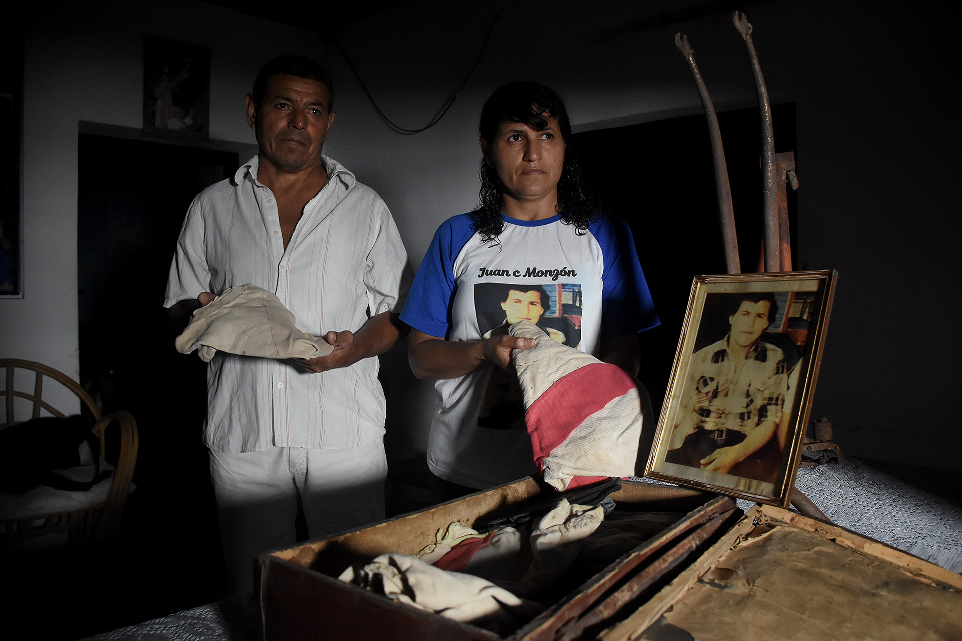 Ana y Guido Monzón con una pequeña valija de cuero gastado que dejó su hermano Juan Carlos en la casa de San Bernardo, Chaco. "Mami, guárdeme estas cosas hasta que vuelva de la guerra", le había dicho a su madre, Marciana, antes de partir junto al Regimiento 12 de Infantería de Corrientes. "Mamá guardó esta valijita debajo de su cama hasta el día que murió", contó Ana. El certificado de defunción dice que cayó en combate el 28 de mayo de 1982, en la cruenta batalla de Darwin-Pradera del Ganso (Matías Arbotto)