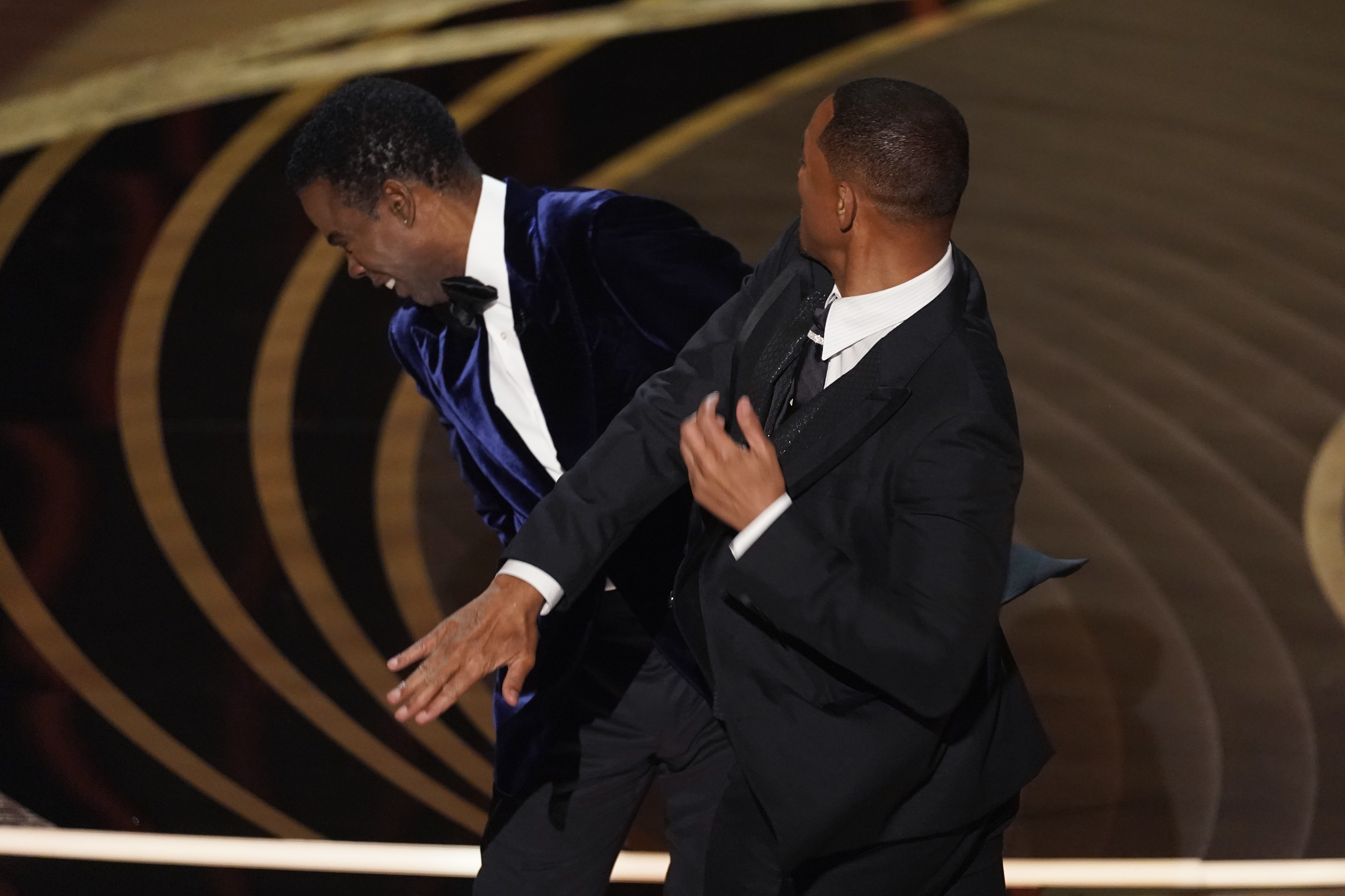 Will Smith, derecha, le da una bofetada al presentador Chris Rock en el escenario durante el anuncio de la cinta ganadora del Premio de la Academia a mejor documental  (Foto AP/Chris Pizzello)