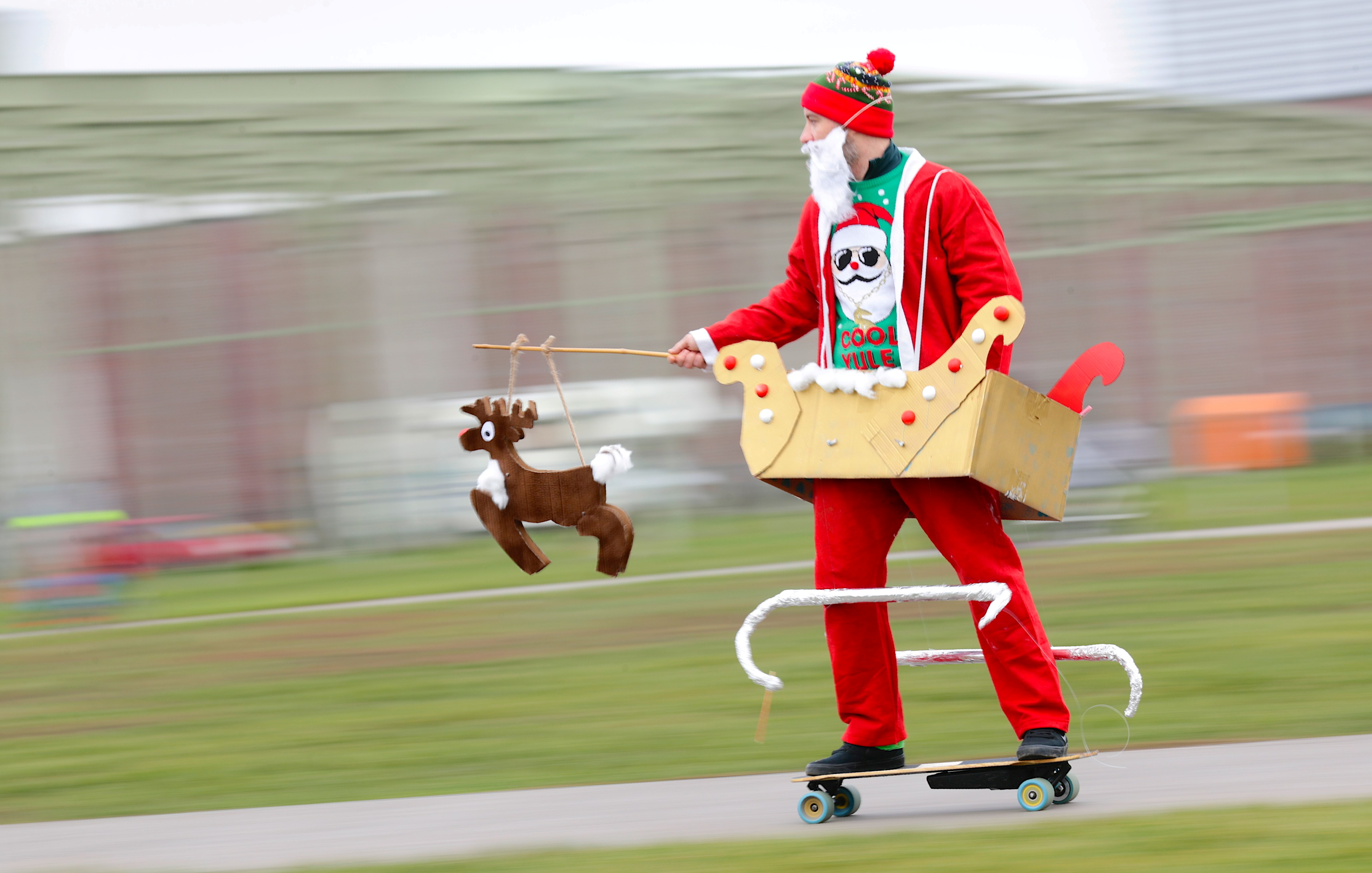 Lars Goetting vestido de Papá Noel, conduce un monopatín eléctrico en Berlín, Alemania (REUTERS/Hannibal Hanschke)