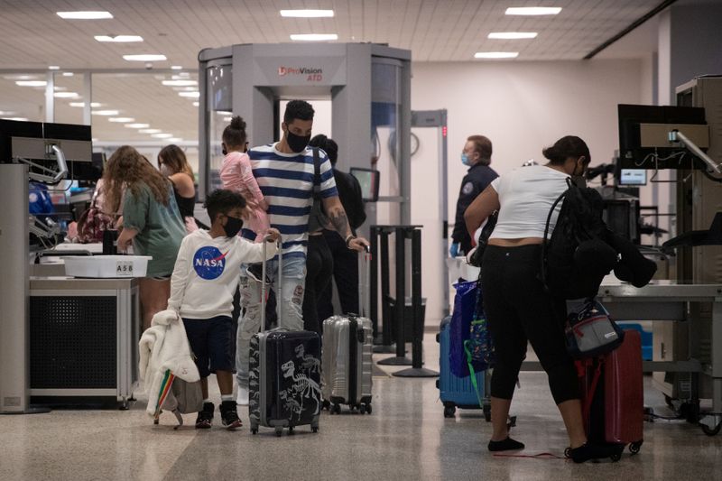 Una familia usa mascarillas al pasar la seguridad en la Terminal A del Aeropuerto Intercontinental George Bush en medio del brote de la enfermedad coronavirus (COVID-19) en Houston, Texas, Estados Unidos (REUTERS/Adrees Latif)