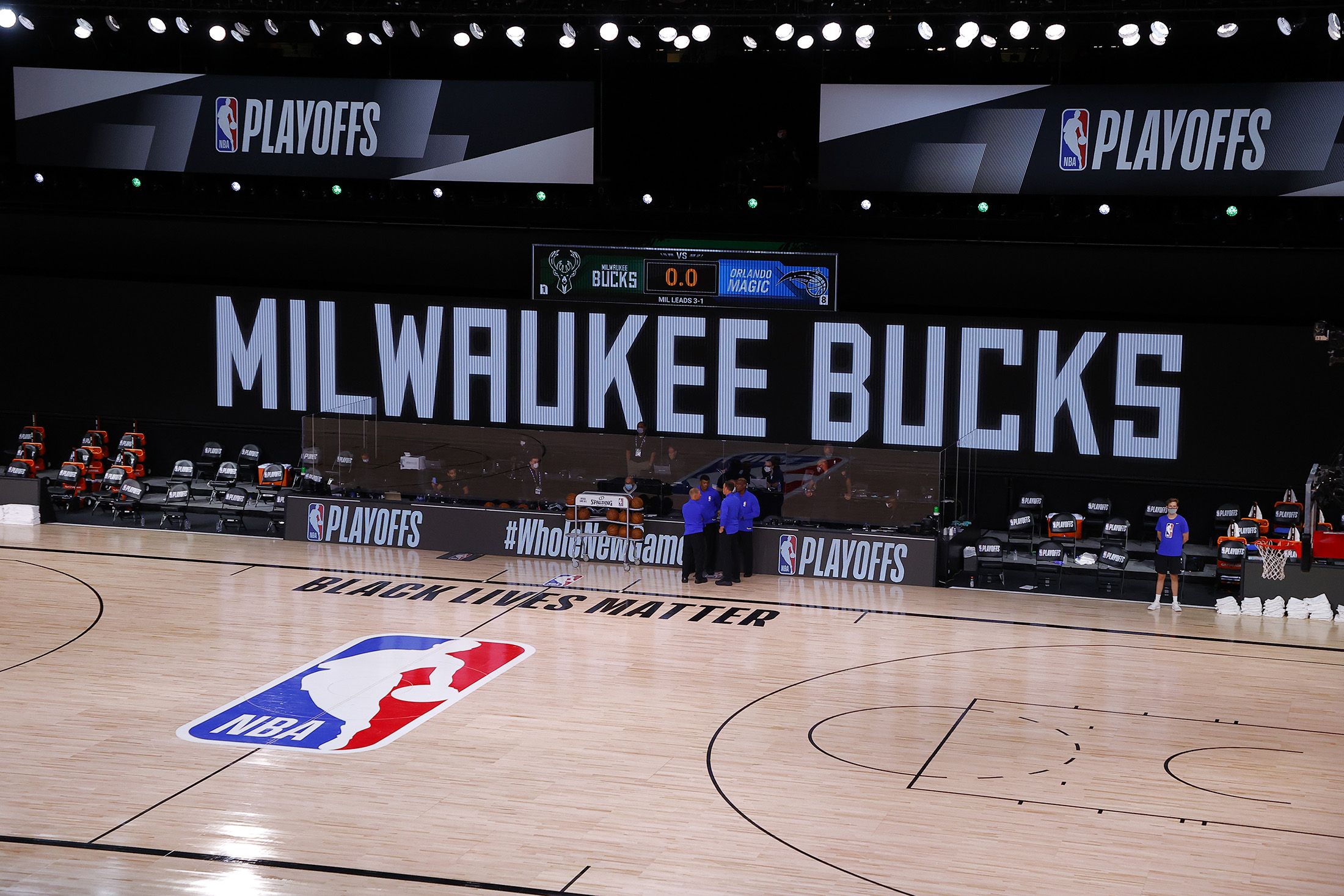 Los árbitros se reúnen en una cancha vacía para el juego entre los Milwaukee Bucks y Orlando Magic que finalmente no se disputó debido al boicot de los jugadores