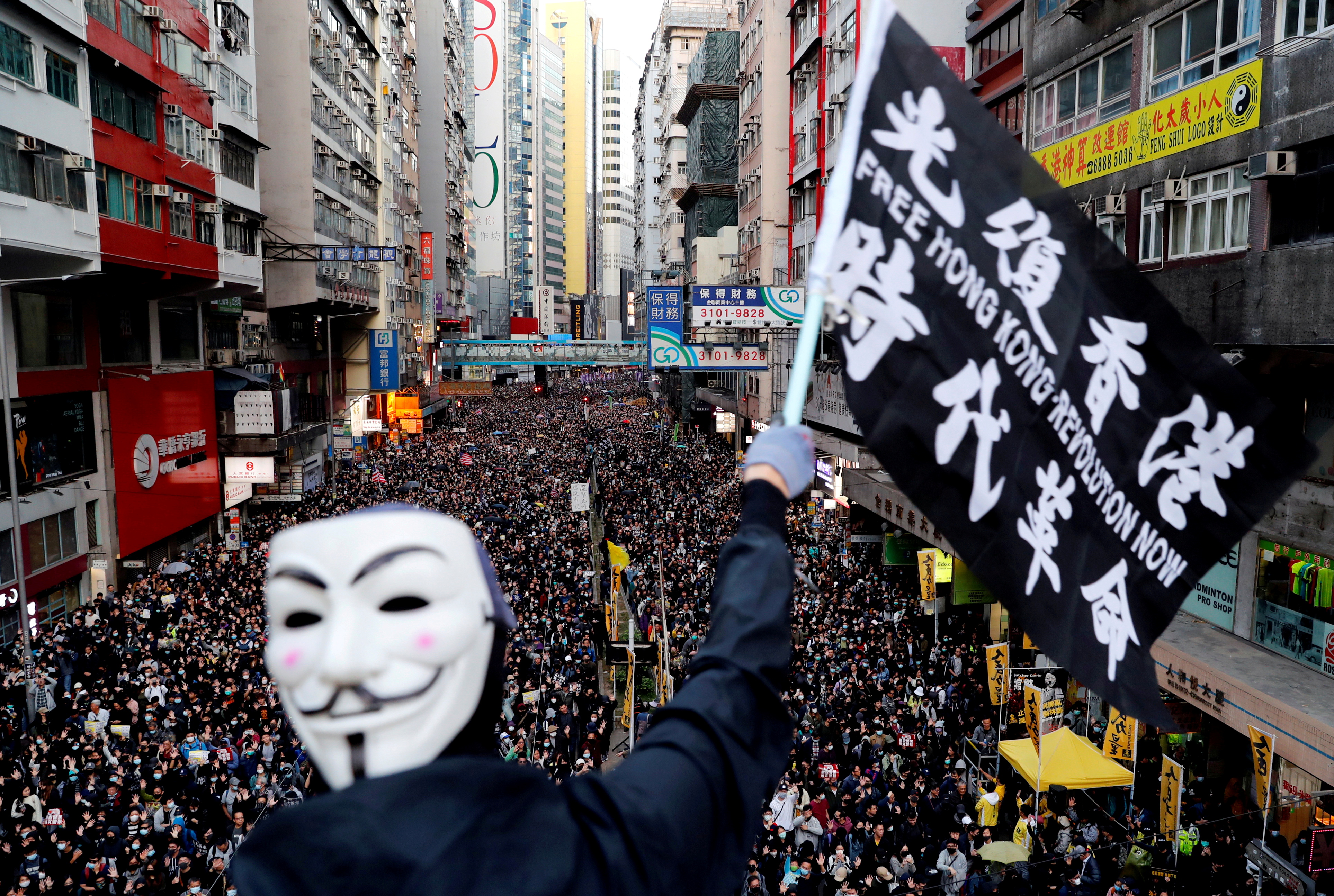 Un manifestante con una máscara de Guy Fawkes agita una bandera durante una marcha del Día de los Derechos Humanos, organizada por el Frente Civil de Derechos Humanos, en Hong Kong, China el 8 de diciembre de 2019.