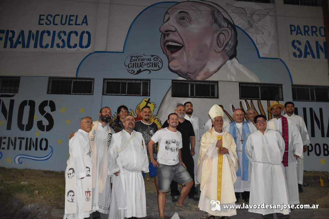 El obispo García junto a un grupo de sacerdotes y laicos frente al mural que homenajea al papa Francisco