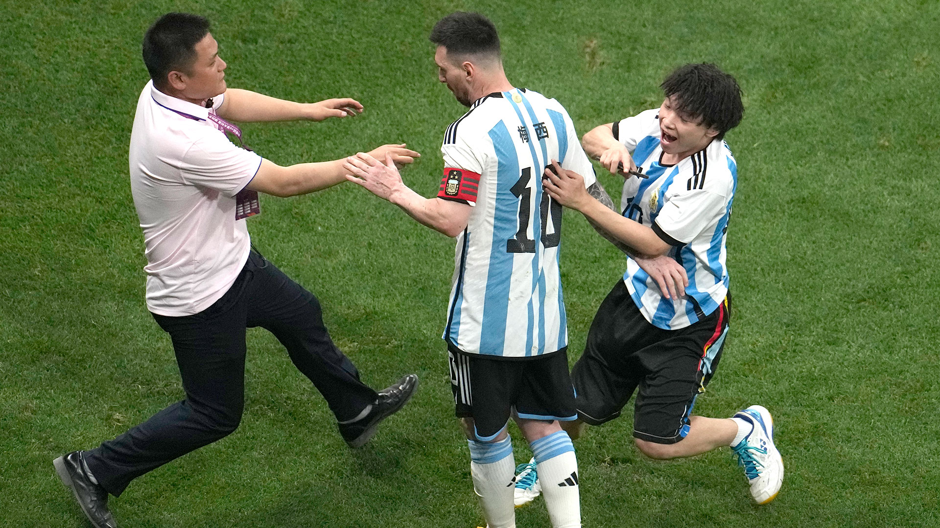 Un hincha invadió el campo de juego para abrazar a Lionel Messi en el amistoso entre Argentina y Australia en Beijing (AP Photo/Ng Han Guan)