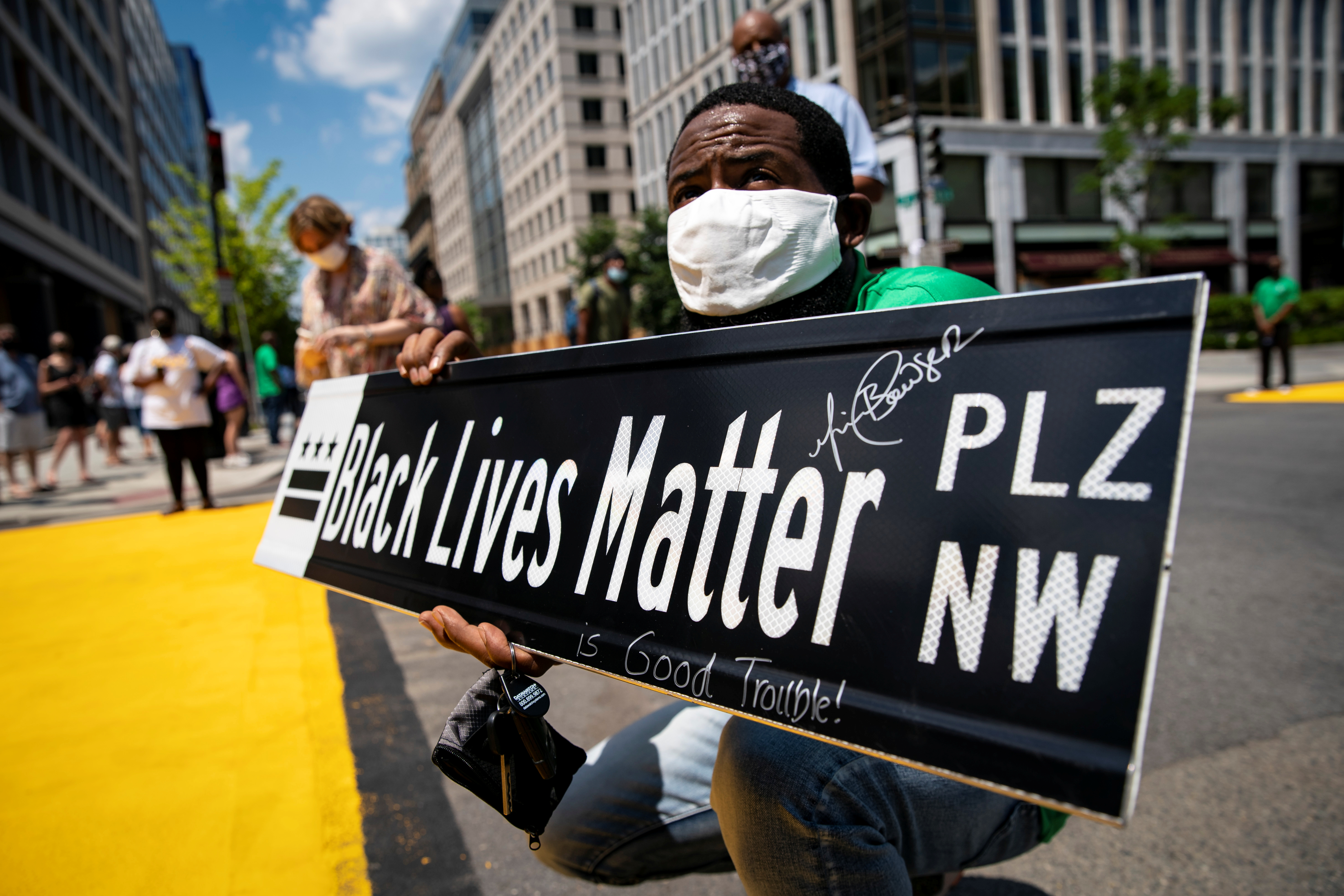 Un hombre sostiene un letrero de la calle Black Lives Matter, en Washington, EE.UU., el 27 de julio de 2020. REUTERS/Al Drago