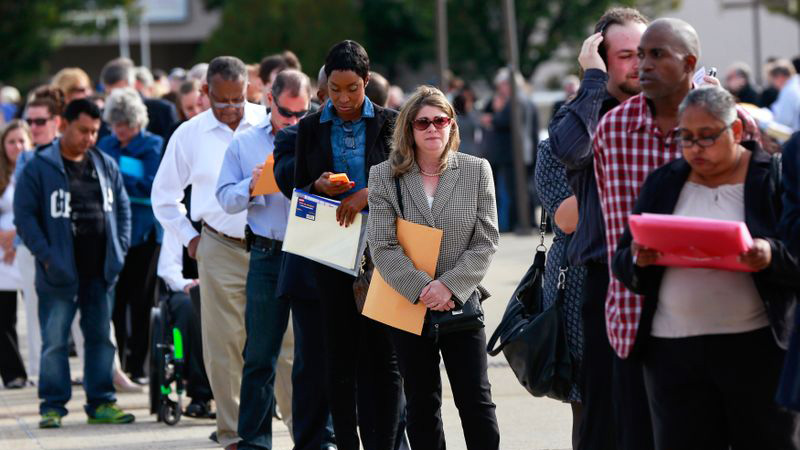 Un grupo de personas haciendo fila en busca de empleo en Nueva York.