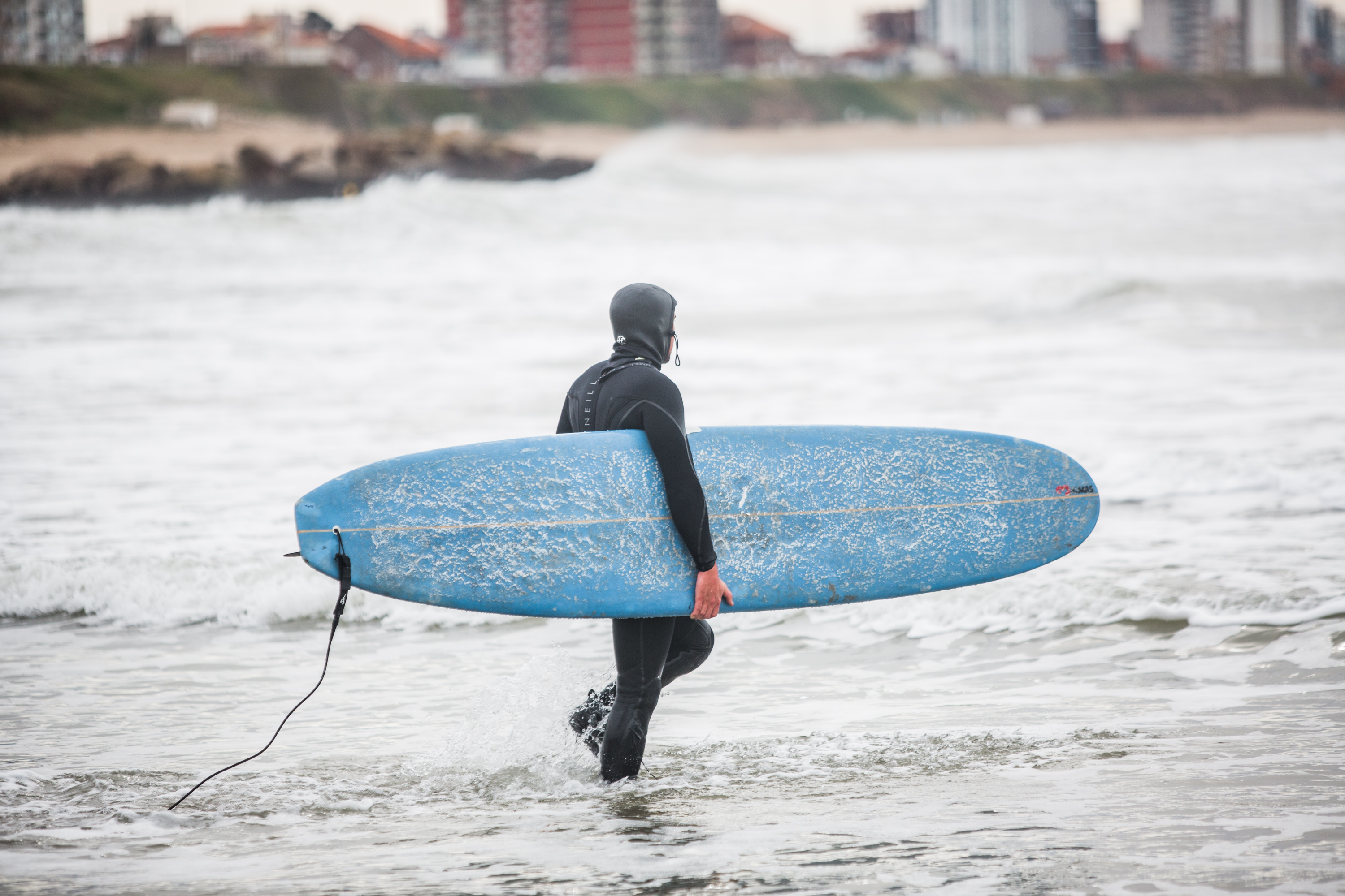 Con un grueso traje de neoprene, un surfer entra al mar. Un sueño que debió esperar más de tres meses para concretarse.