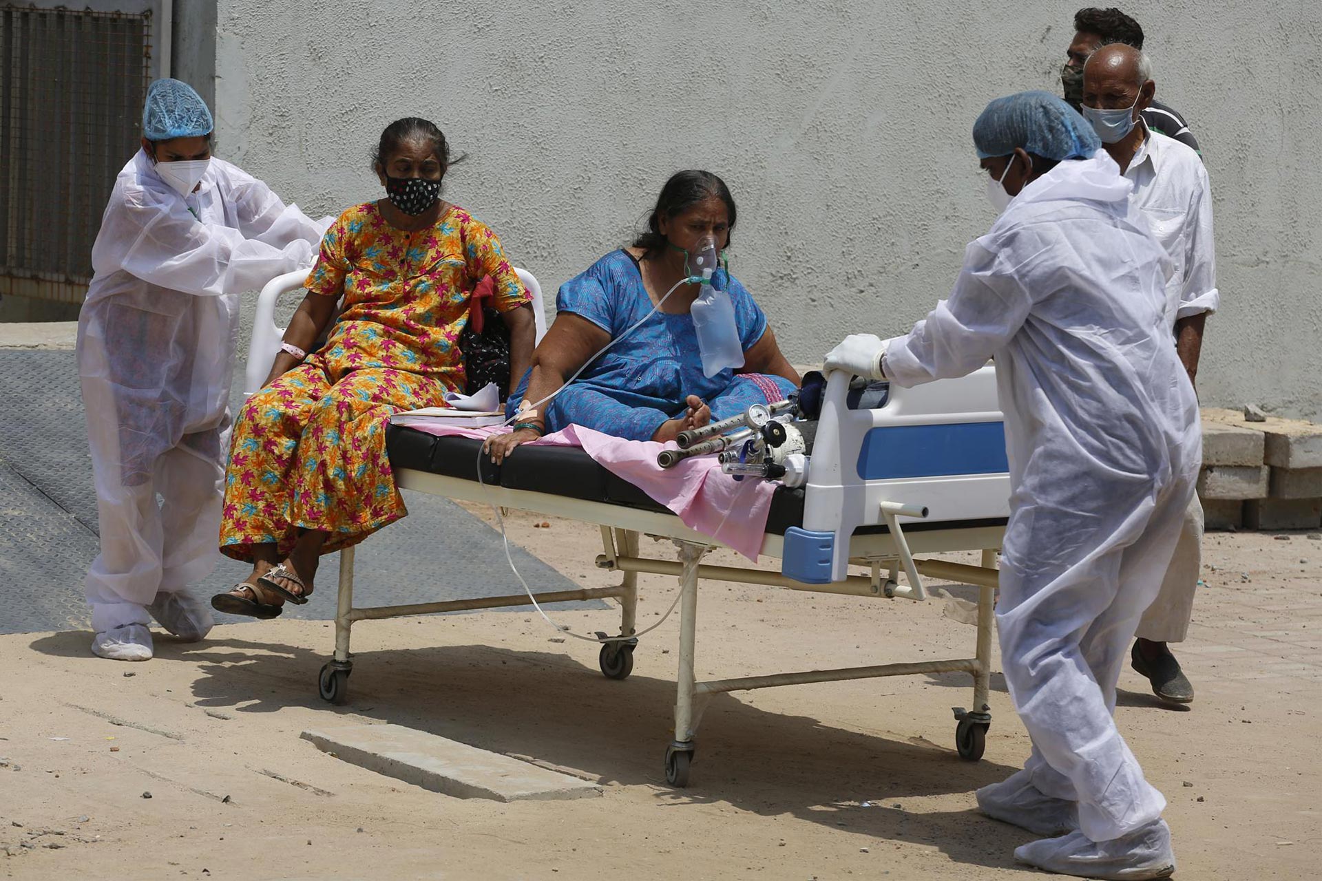 Un trabajador de la salud transporta a los pacientes para trasladarlos de un hospital dedicado al COVID-19 a otro hospital para desocupar la cama para nuevos pacientes, en el hospital Civil de Ahmedabad, India, el martes 13 de abril de 2021 (AP Photo / Ajit Solanki).