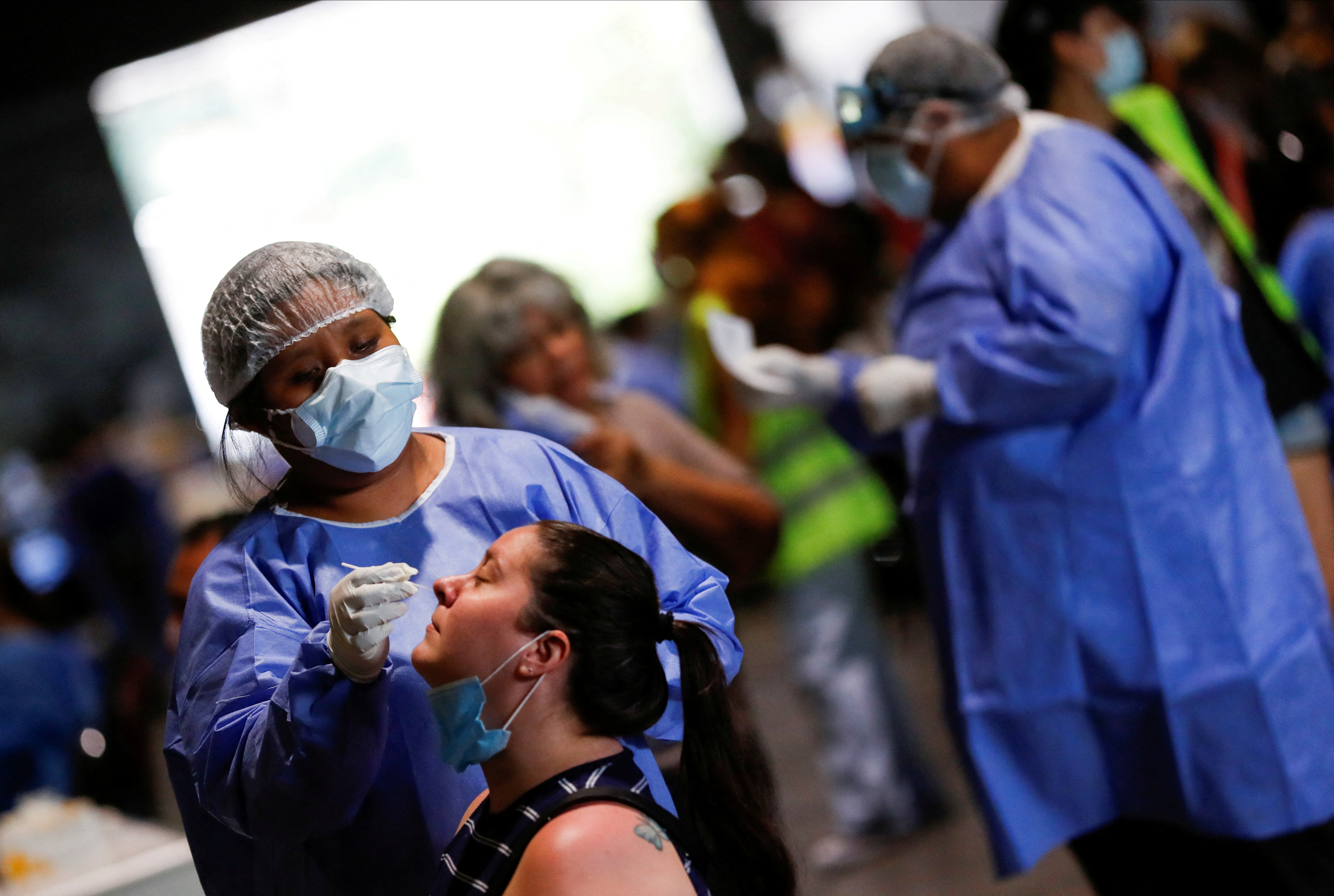 FILE PHOTO: A healthcare worker takes a swab sample from a woman to be tested for coronavirus disease (COVID-19) at La Rural, Buenos Aires, December 23, 2021.  The photo was taken on December 23, 2021.  REUTERS/Agustin Marcarian/File Photo