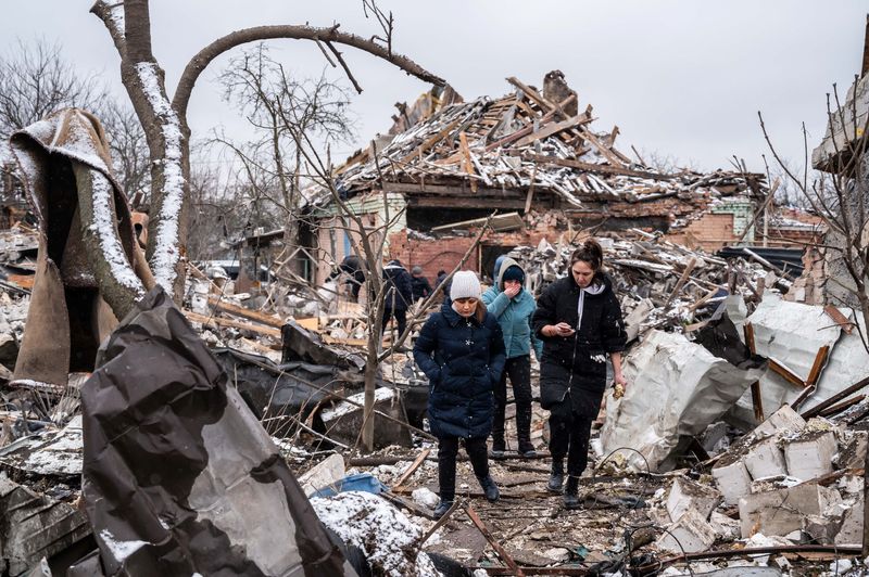 Mujeres caminan entre los restos de edificios residenciales destruidos por los bombardeos, mientras continúa la invasión rusa de Ucrania, en Zhitómir, Ucrania, 2 de marzo de 2022. REUTERS/Viacheslav Ratynskyi