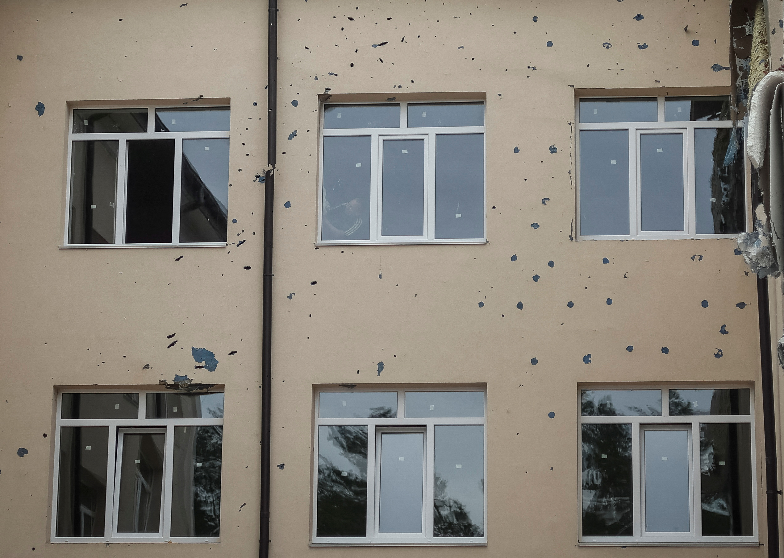 Se ven rastros de fragmentos mientras un trabajador reemplaza las ventanas que se volaron durante un ataque de artillería rusa en una escuela en la ciudad de Irpin, región de Kyiv, Ucrania, 10 de agosto de 2022. REUTERS/Gleb Garanich