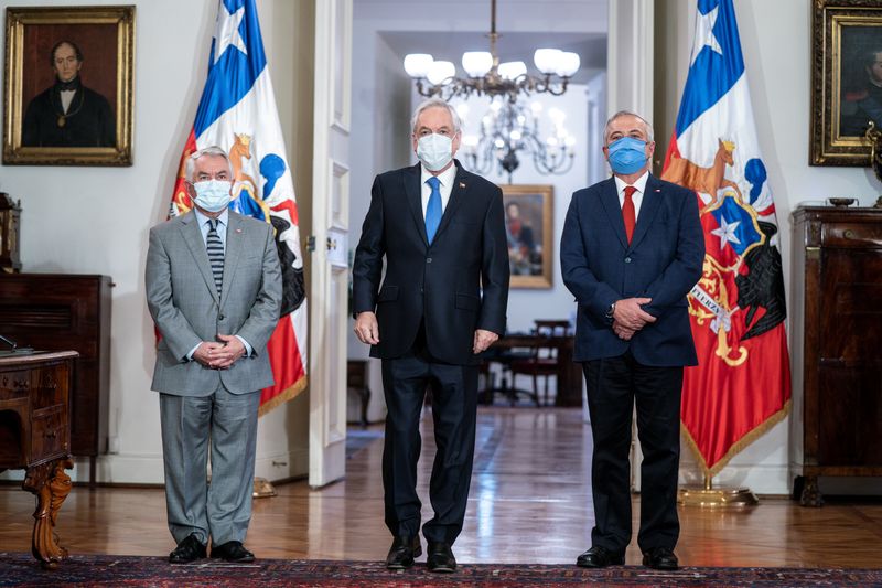El presidente chileno, Sebastián Piñera (al centro), el nuevo ministro de Salud, Óscar Enrique Paris (a la izquierda), y el exministro de Salud Jaime Mañalich asisten a un cambio de gabinete en el Palacio de Gobierno, en medio de la pandemia de COVID-19, la enfermedad causada por el coronavirus.