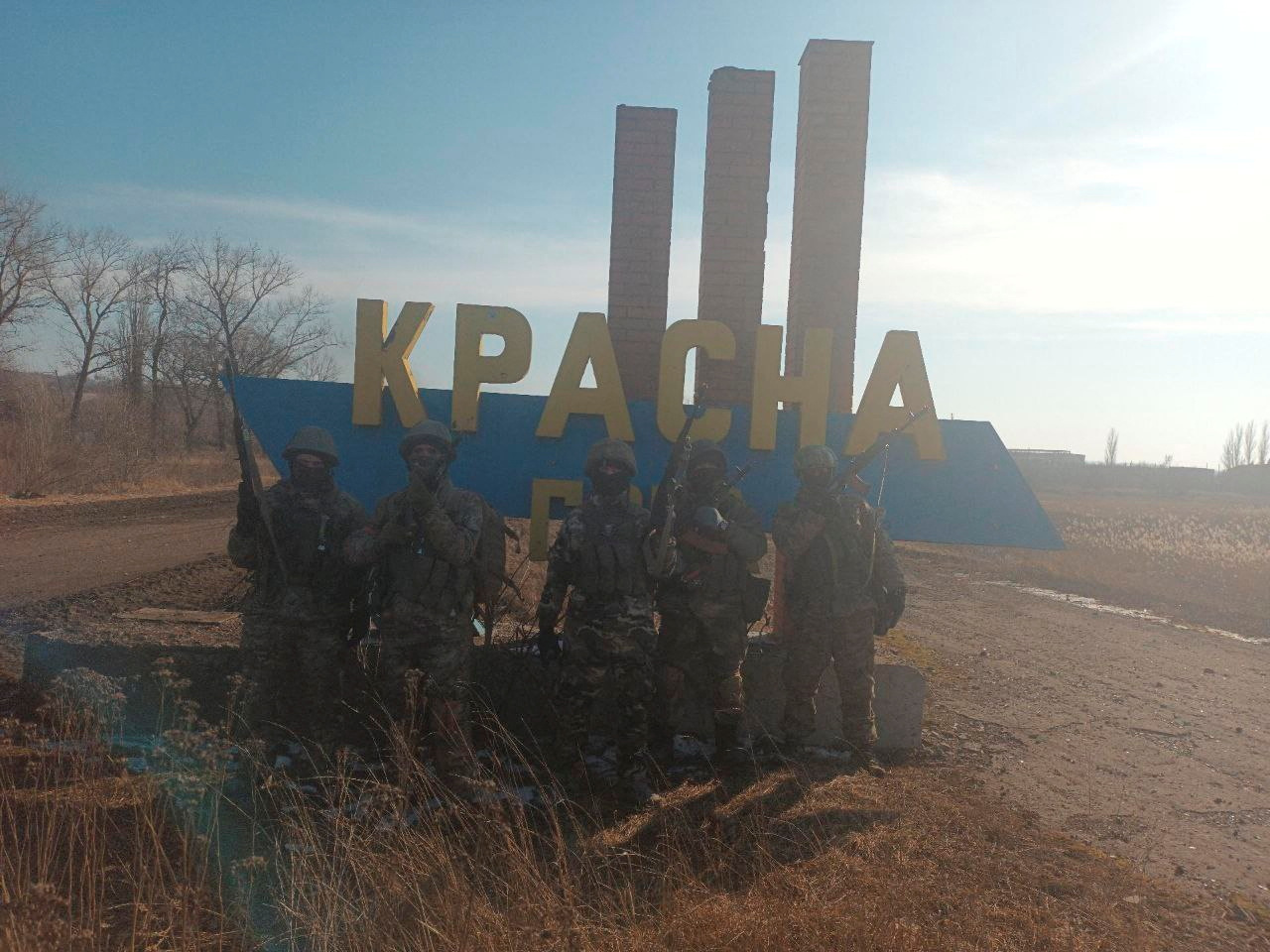 Combatientes de Wagner posando para una foto en la señal de entrada a la aldea de Krasna Hora, cerca de la asediada ciudad de Bakhmut, Ucrania (REUTERS)