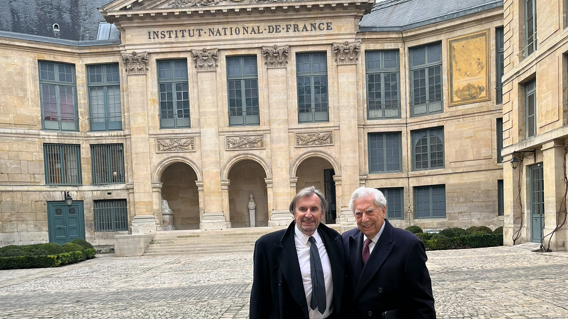 Mario Vargas Llosa posa sonriente frente al Instituto Nacional de Francia antes de dar los primeros pasos para entrar en la Academia Francesa de la Lengua (Cuenta de Twitter de Álvaro Vargas Llosa)
