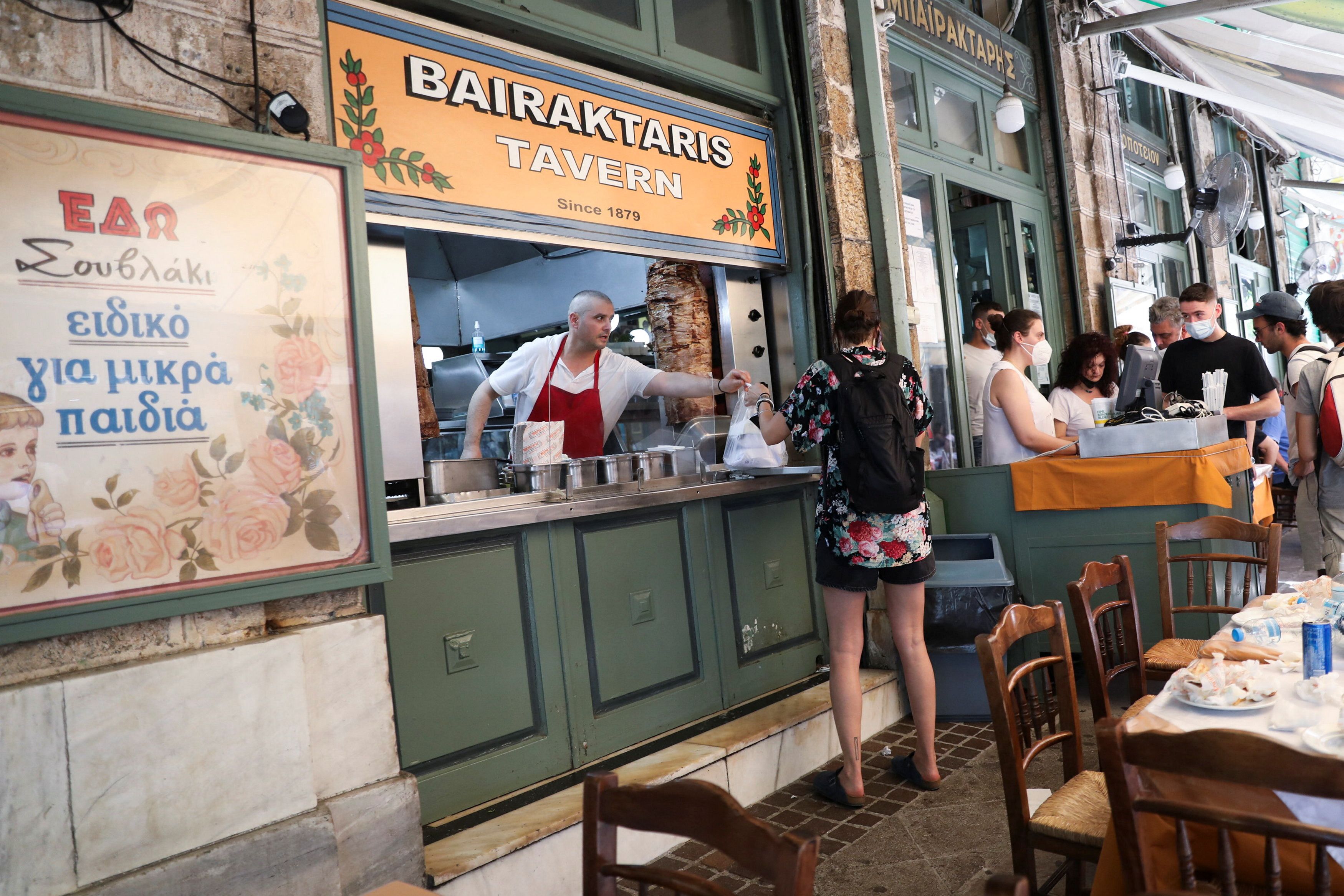 Un cocinero entrega un souvlaki a un cliente en Grecia (REUTERS/Louiza Vradi)