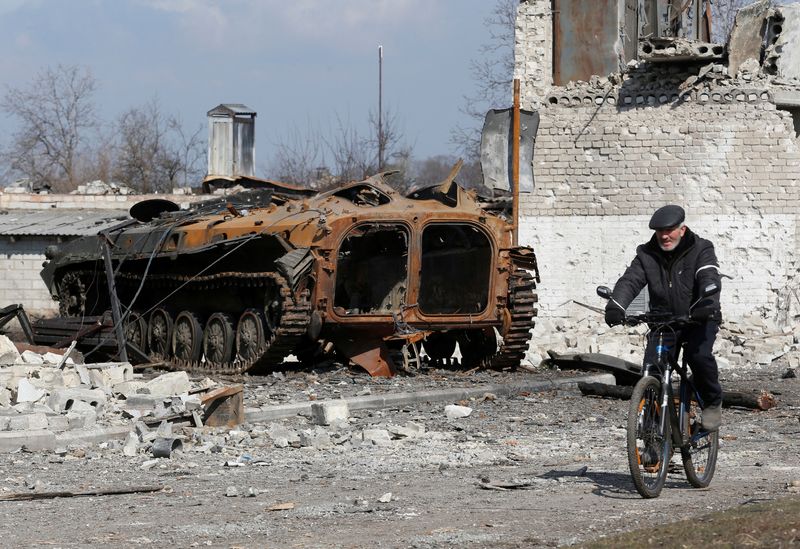 Un residente local pasa en bicicleta frente a un vehículo blindado carbonizado durante el conflicto entre Ucrania y Rusia en la ciudad de Volnovakha, controlada por los separatistas, en la región de Donetsk, Ucrania, el 15 de marzo de 2022. REUTERS/Alexander Ermochenko