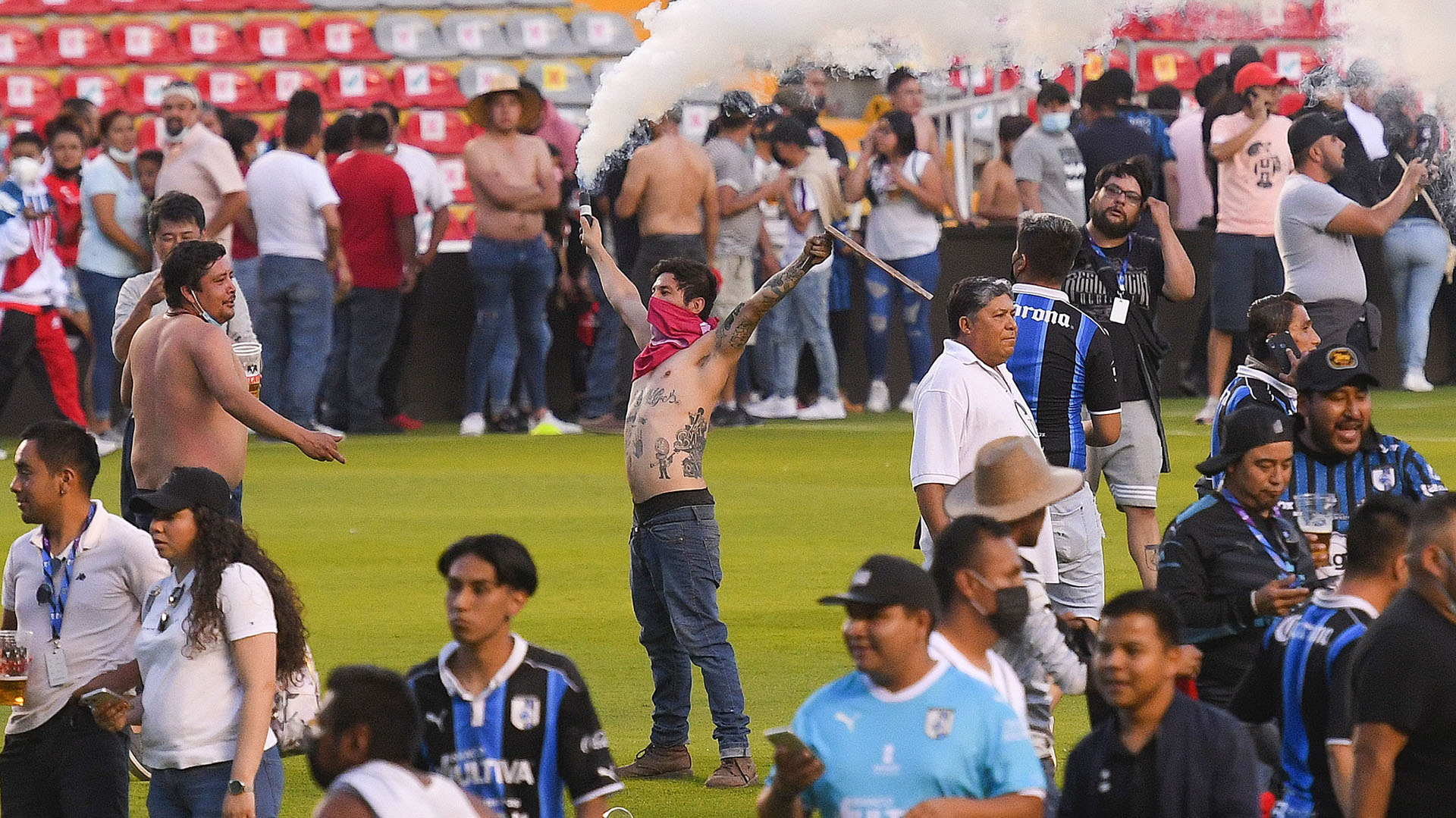 Aficionados del Querétaro y aficionados del Atlas originaron un conato de pelea que terminó invadiendo la cancha (Foto: EFE)