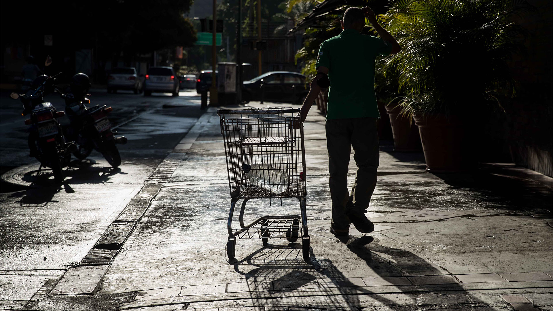 Un hombre recolecta agua potable en unos recipientes en Caracas (EFE/ Miguel Gutiérrez)