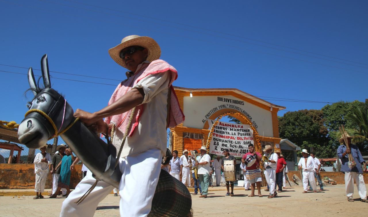 Xochistlahuaca, Guerrero, México. 1 de noviembre de 2020. Con la danza del “macho mula” indígenas amuzgos recorren las calles de Xochistlahuaca iniciando una procesión para traer a los muertos desde el panteón del pueblo hasta un altar realizado por vecinos del barrio del campo, esta es una de las tradiciones de la festividad de día de muertos en esta comunidad, en donde la mayoría de sus habitantes a decidido no participar para evitar contagios de covid-19.
