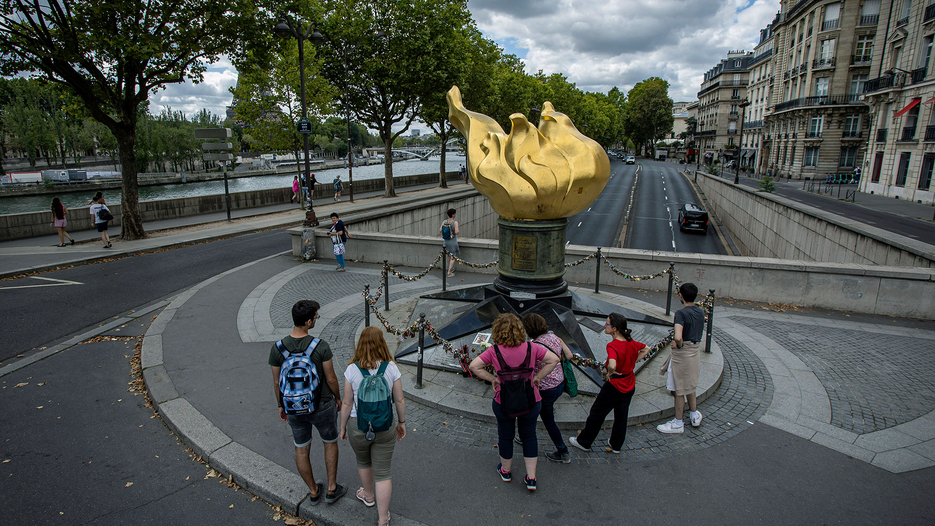 La gente se para junto a la estatua dorada Llama de la Libertad que sirve como un santuario no oficial para la princesa Diana, el lunes 22 de agosto de 2022 en París. (Foto AP/Aurélien Morissard)

