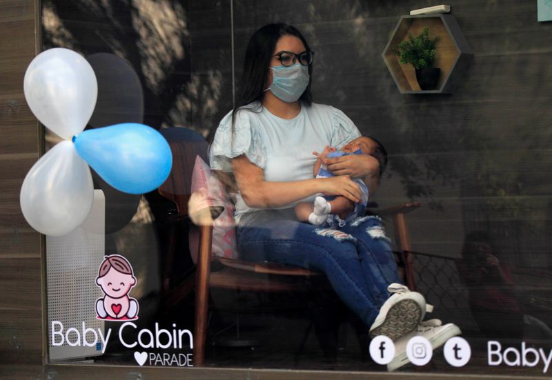 Foto de archivo con su bebe recién nacido en una cabina sanitizada mostrando al pequeño a sus familiares, en medio de la pandemia de coronavirus
Jul 31, 2020. REUTERS/Daniel Becerril