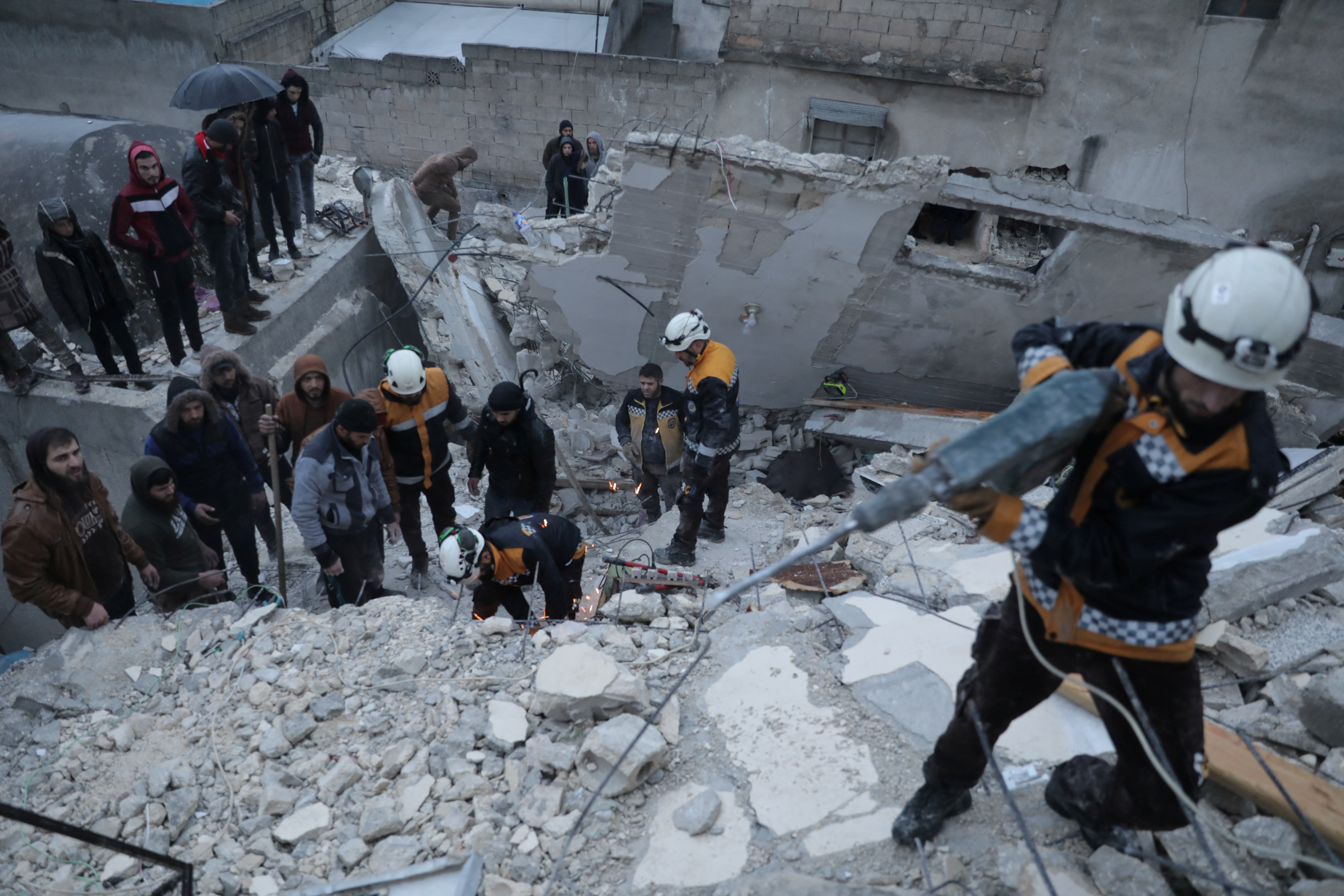 Rescatistas sobre un edificio colapsado en Idlib, Siria.
