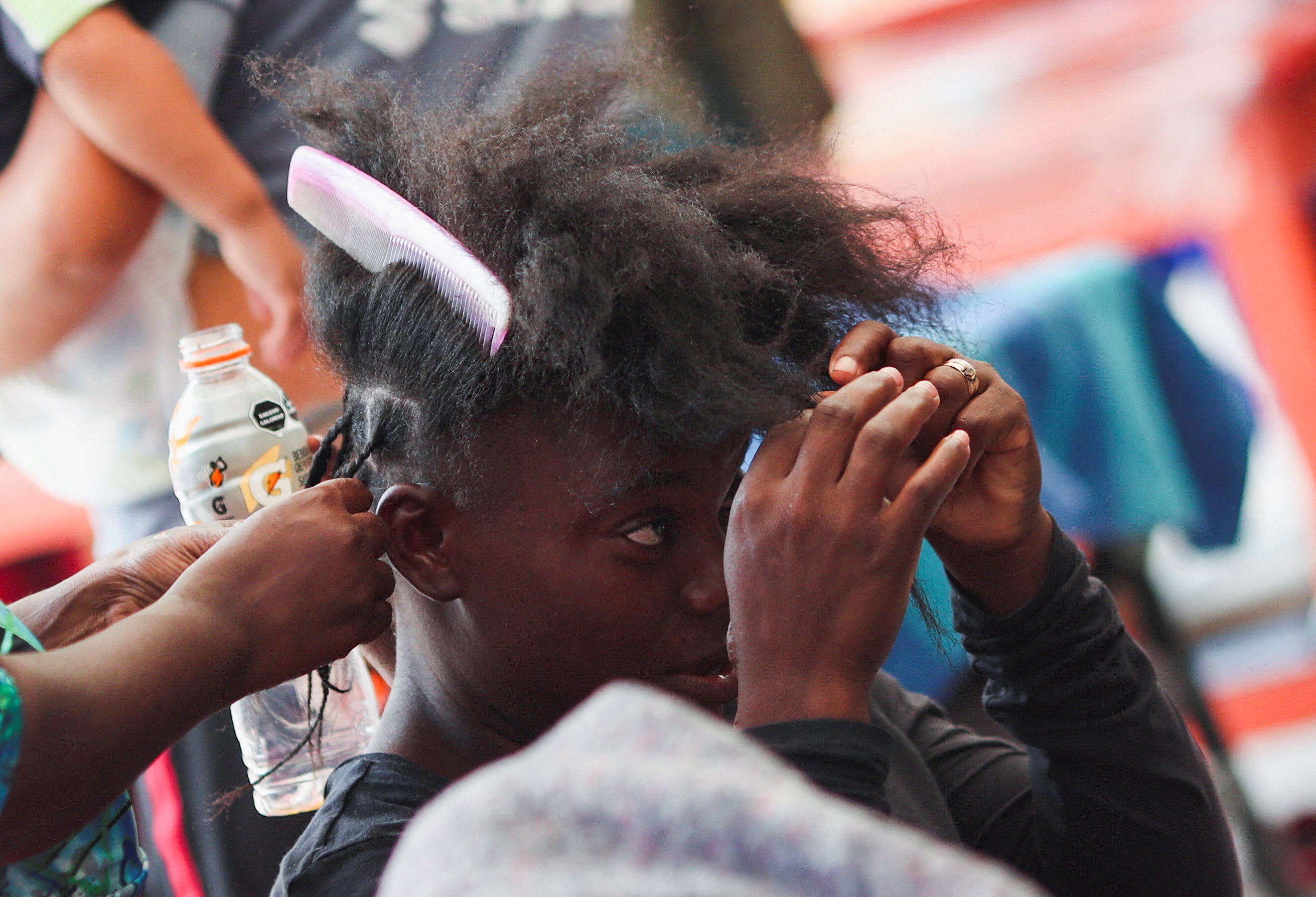 Un migrante, de Haití, trenza el cabello de otro compatriota en su viaje hacia la frontera entre México y Estados Unidos, en la Ciudad de México (REUTERS /Henry Romero )