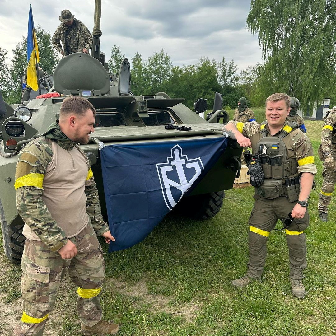 Miembros del Cuerpo de Voluntarios de Rusia posan junto a un vehículo blindado (Russian Volunteer Corps/Handout via REUTERS)