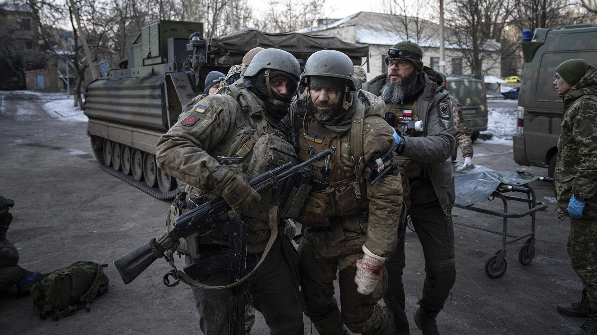 A Ukrainian serviceman carries his wounded comrade evacuated from the battlefield to a hospital in the Donetsk region, Ukraine, Monday, Jan. 9, 2023. (AP Photo/Evgeniy Maloletka)