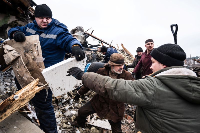 Residentes locales retiran los escombros de un edificio de viviendas destruido por los bombardeos, mientras continúa la invasión rusa de Ucrania (REUTERS/Viacheslav Ratynskyi)