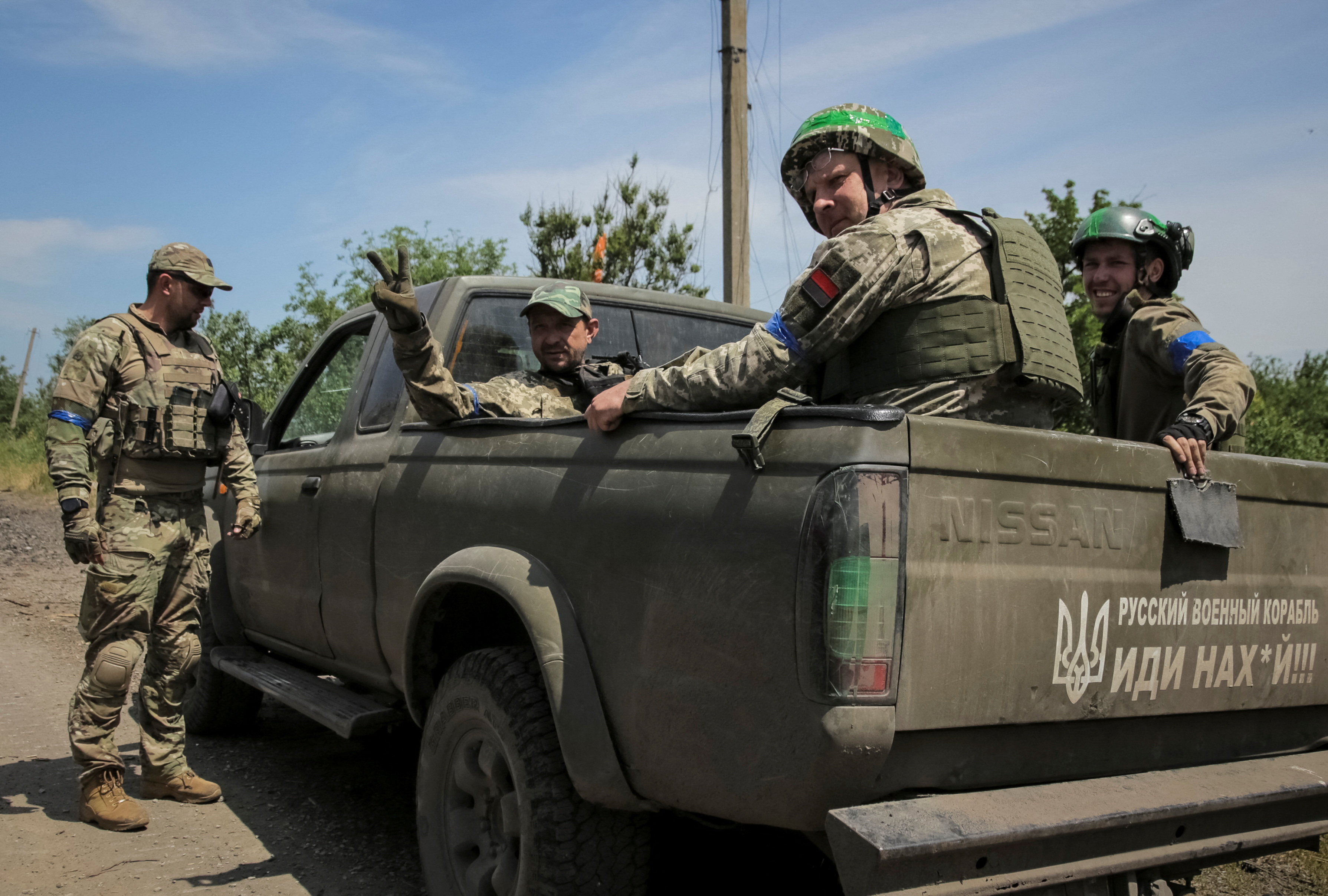 Las tropas ucranianas recorrieron las calles embarradas a lomos de un tanque y en una camioneta. (REUTERS/Oleksandr Ratushniak)