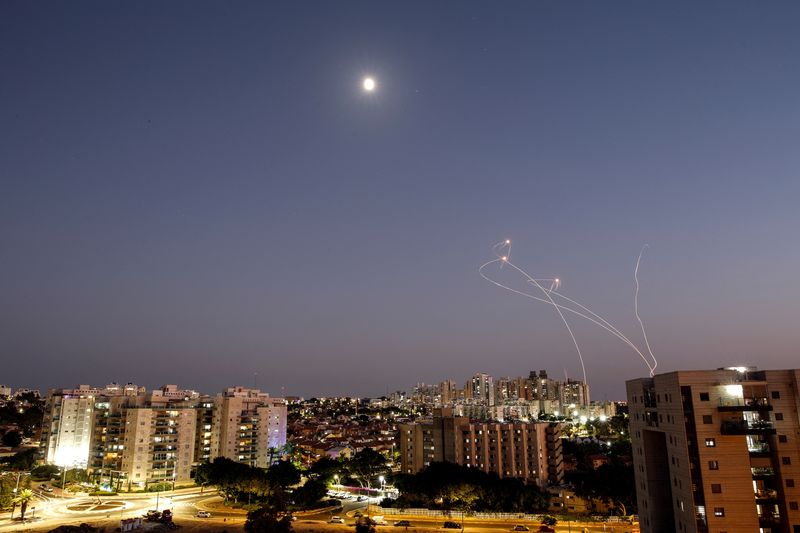Rayos de luz se ven cuando el sistema antimisiles Cúpula de Hierro de Israel intercepta cohetes lanzados desde la Franja de Gaza hacia Israel, visto desde Ashkelon, Israel