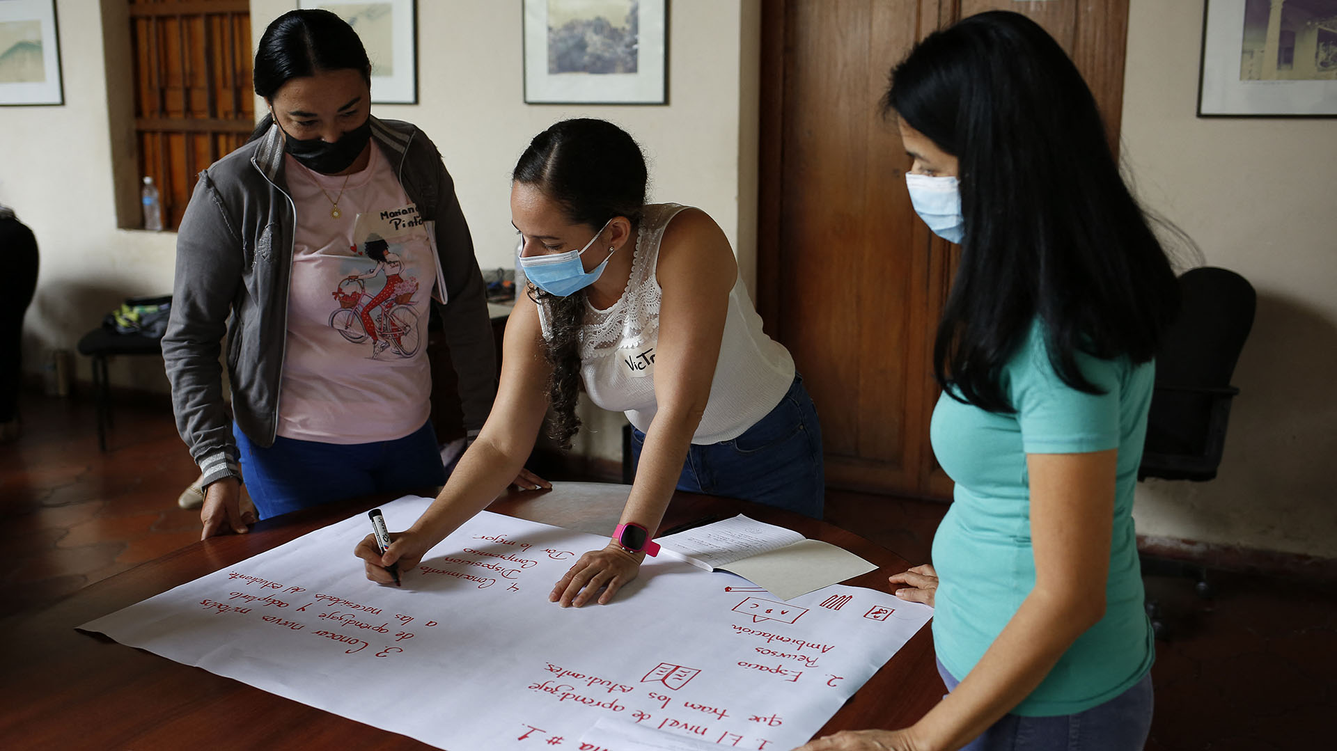 Maestros hacen una hoja de exposición durante una reunión con investigadores en Montalbán, Estado de Carabobo, Venezuela, el 9 de julio de 2022. (Foto de Pedro Rances Mattey / AFP)