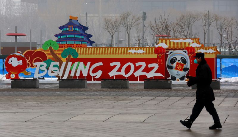 A security guard walks past advertising boards at the Main Press Center ahead of the Beijing 2022 Winter Olympic Games in Beijing, China, January 24, 2022. REUTERS/Fabrizio Bensch