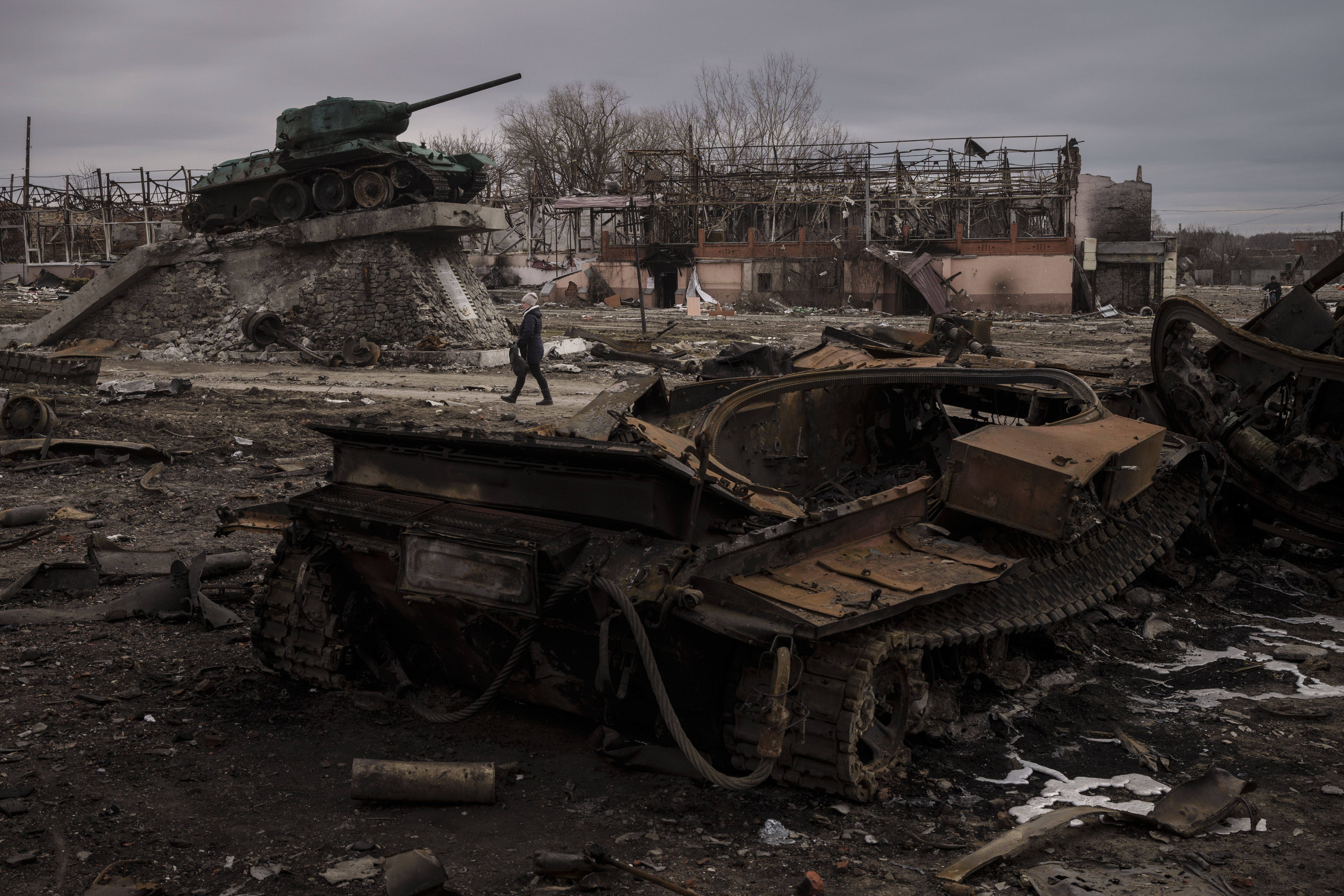 Una mujer pasa frente a un tanque destruido en la ciudad de Trostsyanets (Foto AP/Felipe Dana)