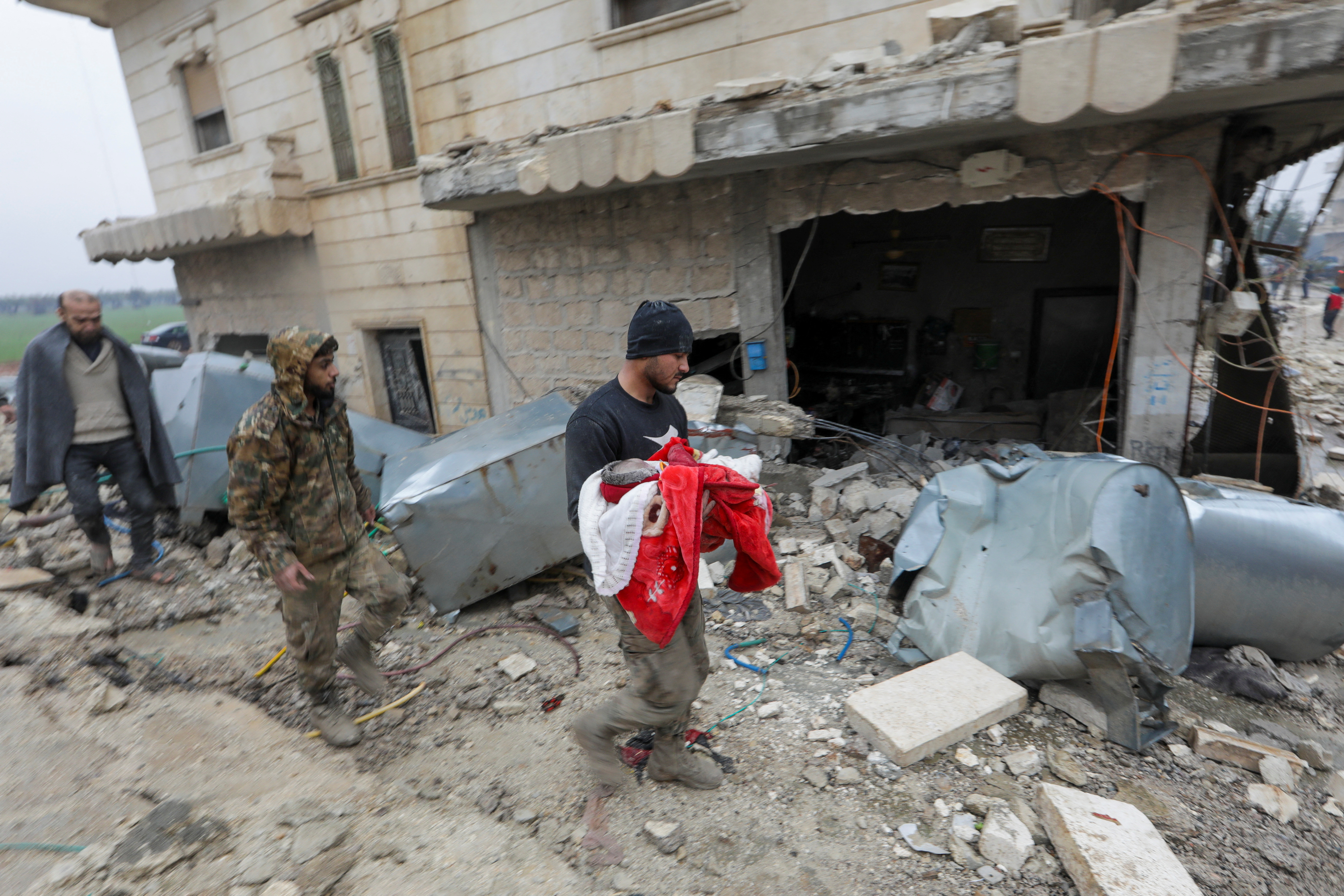 El dolor de un hombre que traslada el cuerpo de un pequeño, víctima mortal del sismo en Jandaris (REUTERS/Khalil Ashawi)