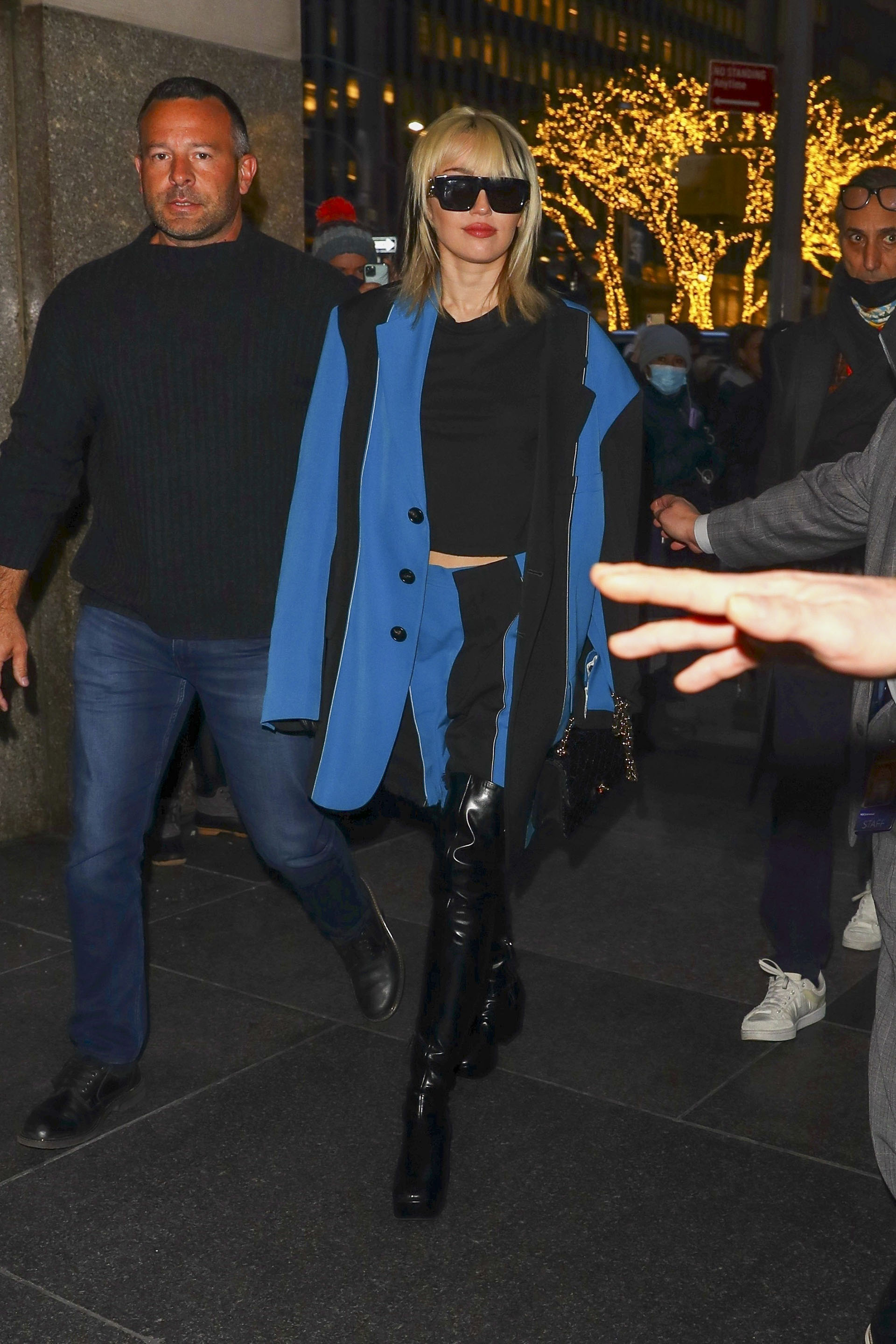 Miley Cyrus siempre marcando tendencia. Esta vez con un blazer azul y una falda con detalles en negro y combinada con botas negras, gafas de sol y un bolso Chanel 