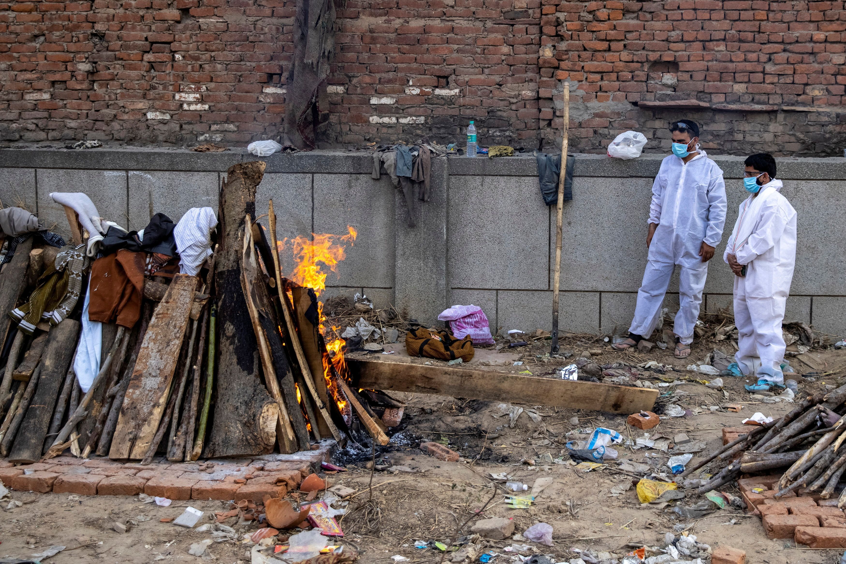 Familiares de personas fallecidas por covid asisten a su crematorio en Nueva Delhi
