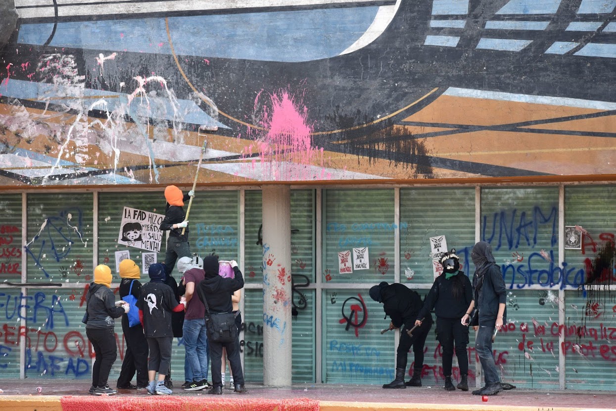 Algunos integrantes encapuchados que participaron durante la manifestación del contingente de estudiantes de la Facultad‭ ‬de‭ ‬Artes‭ ‬y Diseño (FAD) que marcharon por Ciudad Universitaria vandalizaron el mural de David Alfaro Siqueiros, ubicado en la  Torre de la Rectoría.
FOTO: CUARTOSCURO.COM