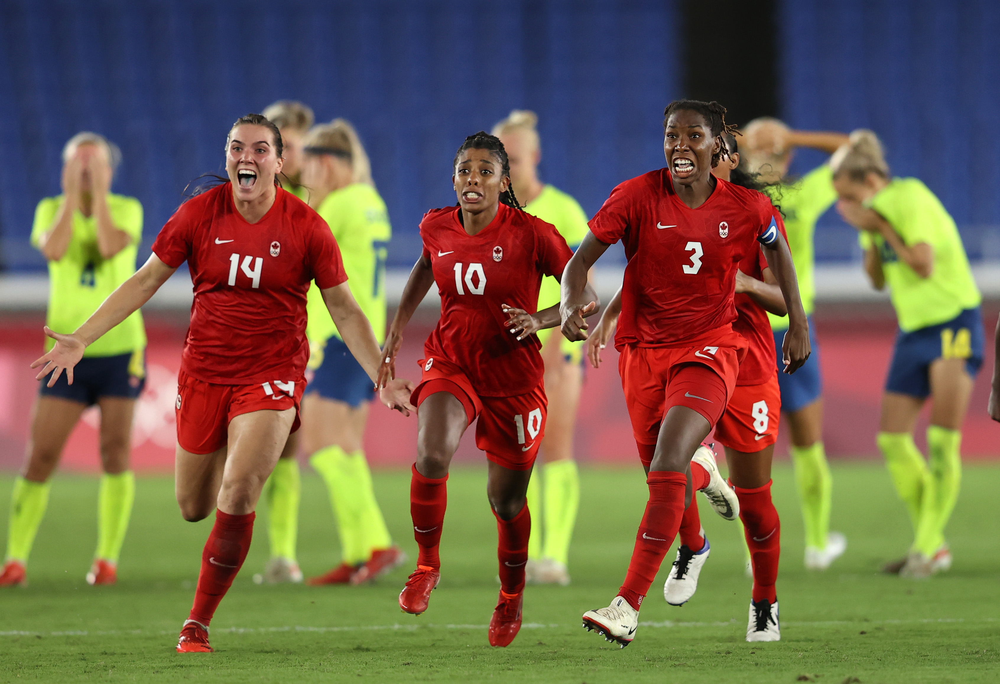 TOKYO, JAPAN - AUGUST 06: Vanessa Gilles #14, Ashley Lawrence #10 and Kadeisha Buchanan #3 of Team Canada celebrate following their team's victory in the penalty shoot out in the Women's Gold Medal Match between Canada and Swedenat Olympic Stadium on August 06, 2021 in Tokyo, Japan. (Photo by Francois Nel/Getty Images)