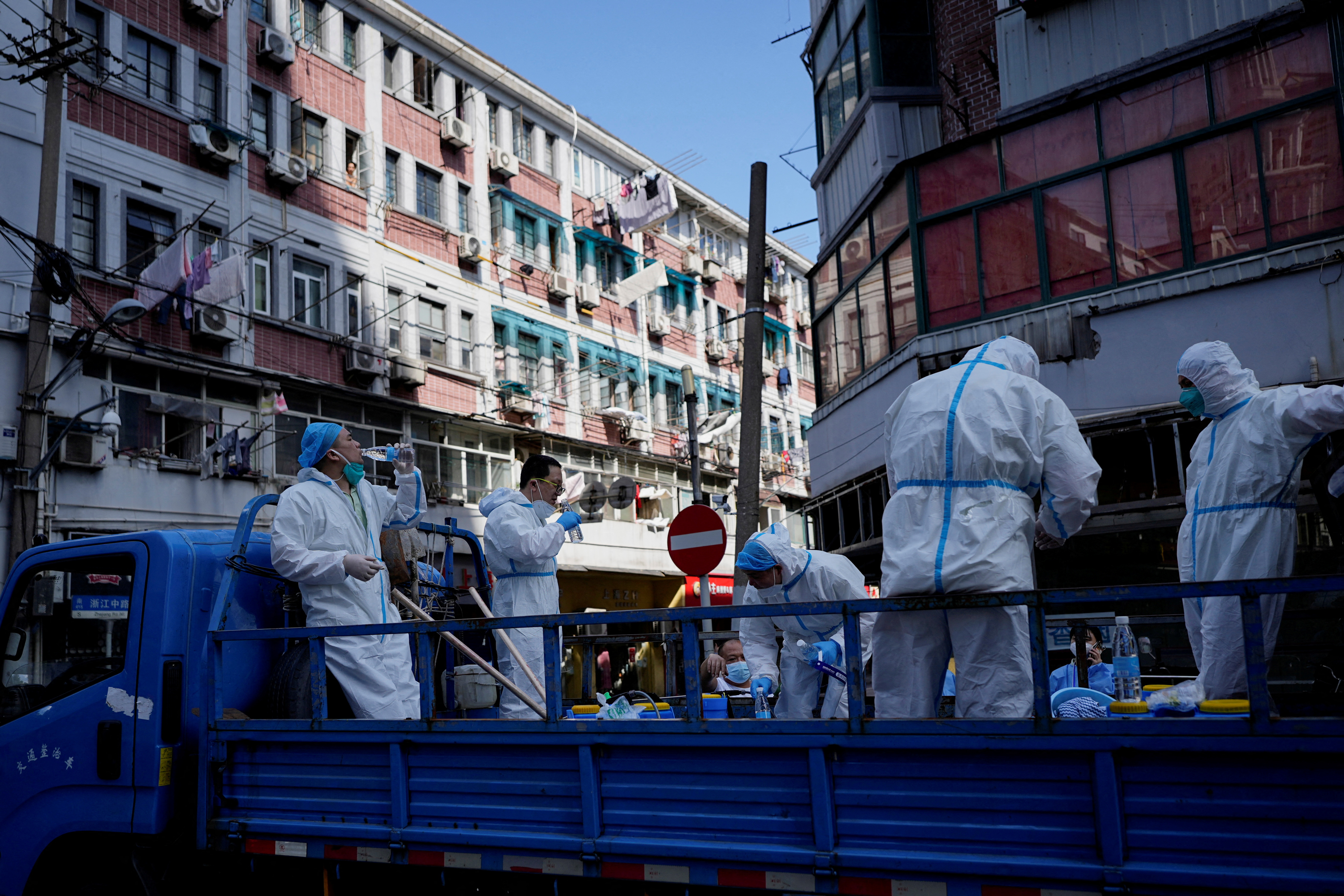 Trabajadores con trajes de protección se suben a un camión mientras la ciudad se prepara para poner fin al cierre colocado para frenar el brote de la enfermedad del coronavirus (COVID-19) en Shanghái, China 31 de mayo de 2022. REUTERS/Aly Song 